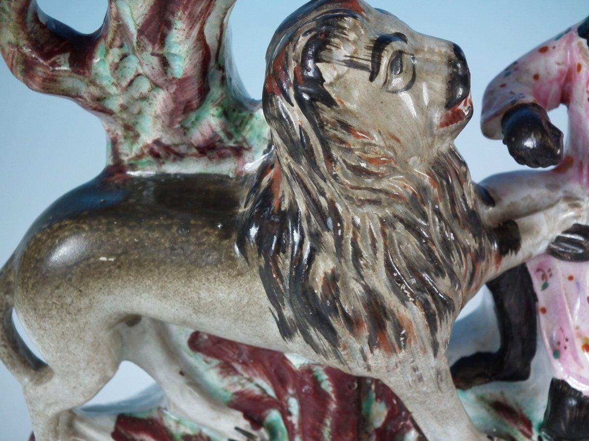 Staffordshire Pottery spill vase with a theatrical and literary theme which features Macombo removing a thorn from the lion's paw, stood on a shaped base. Dull gilt embellishment. Decorated mainly to the front. This piece represents Macombo, the