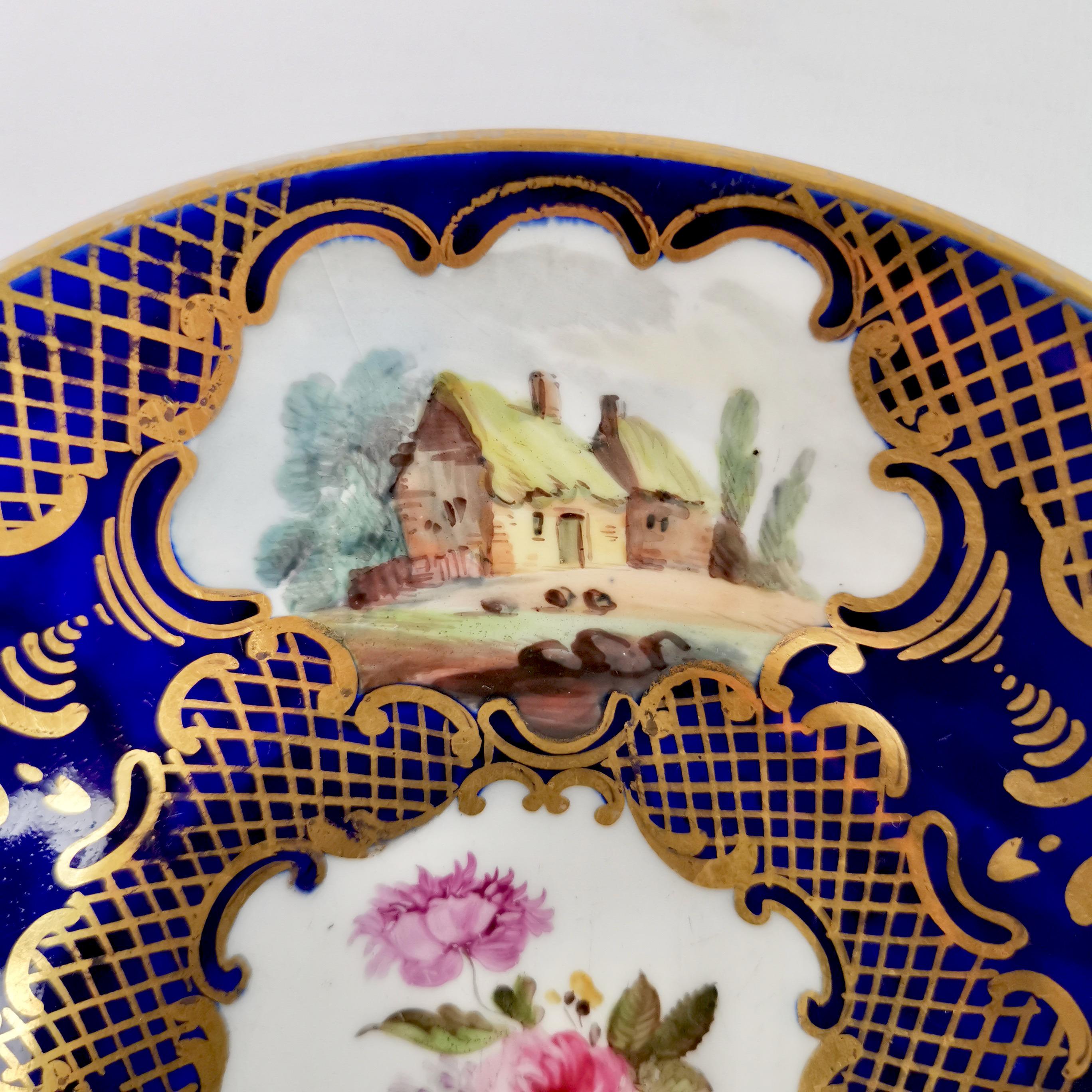 On offer is a very fine small orphaned deep saucer made around the year 1815 by an unknown Staffordshire potter. The saucer has a beautiful deep cobaltblue ground with dramatic gilding and sublime little landscapes and a bouquet of flowers in the