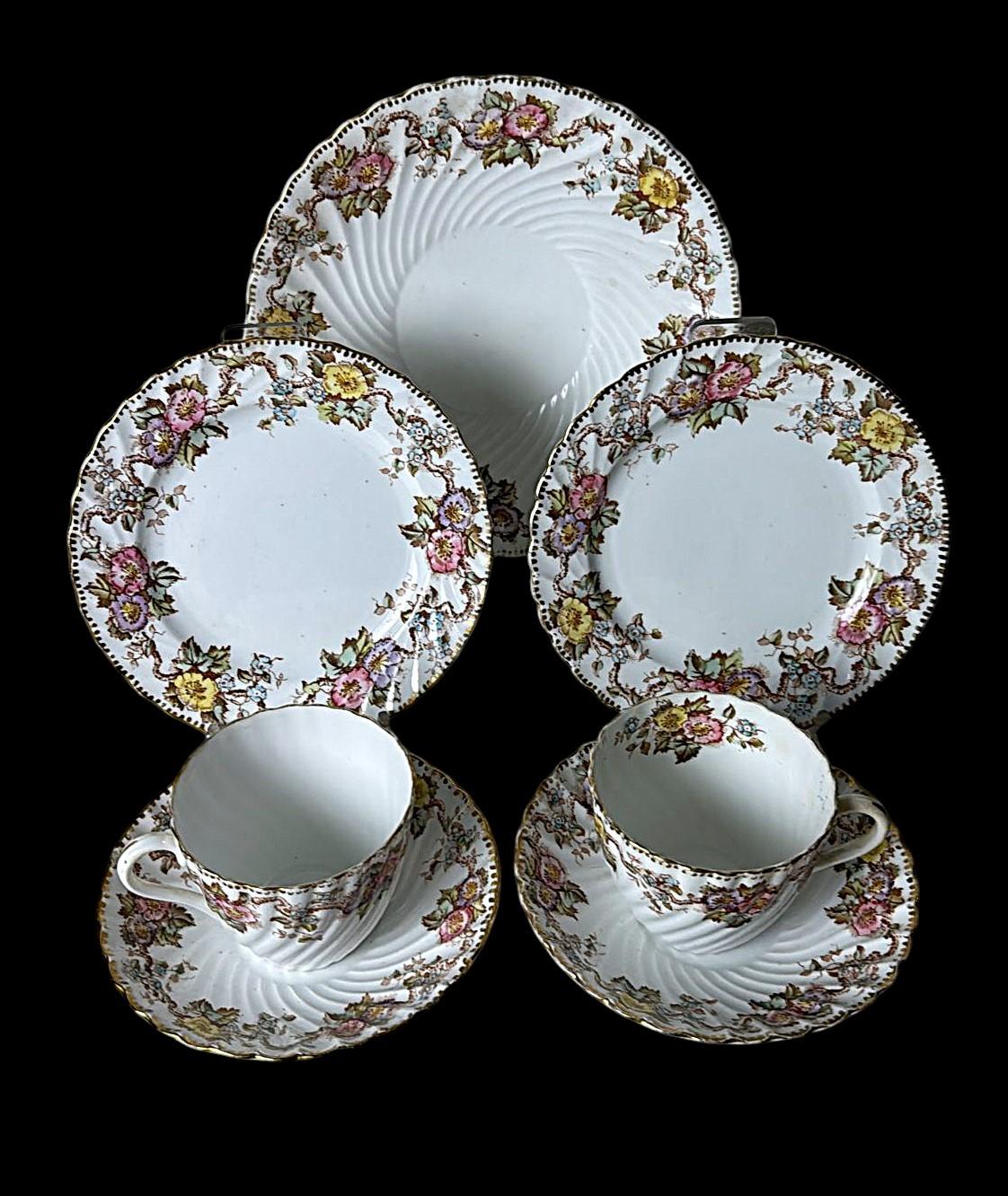 Elegante e delicato set da caffè in porcellana inglese, composto da due tazze con piattini, due piatti da dessert e un vassoio rotondo coordinato. Ogni pezzo porta il marchio di Jones, Shepherd & Co., Church Street, Longton, Stoke-on-Trent,