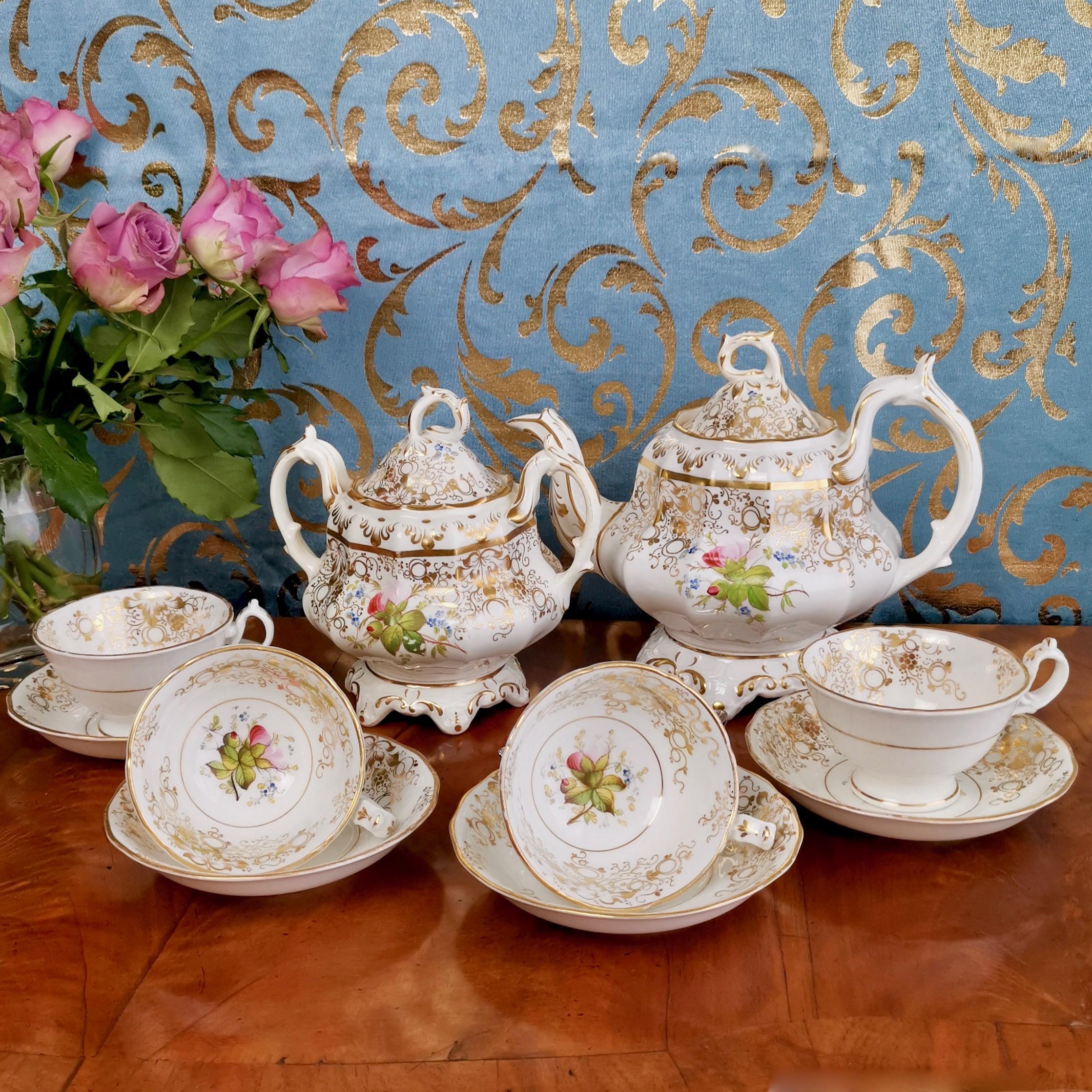 This is a beautiful part porcelain tea service from an unknown Staffordshire maker, produced in circa 1845 in the Rococo Revival style. It is white with beautiful gilt decorations and hand painted flowers. The set has some flaws and comes As Found