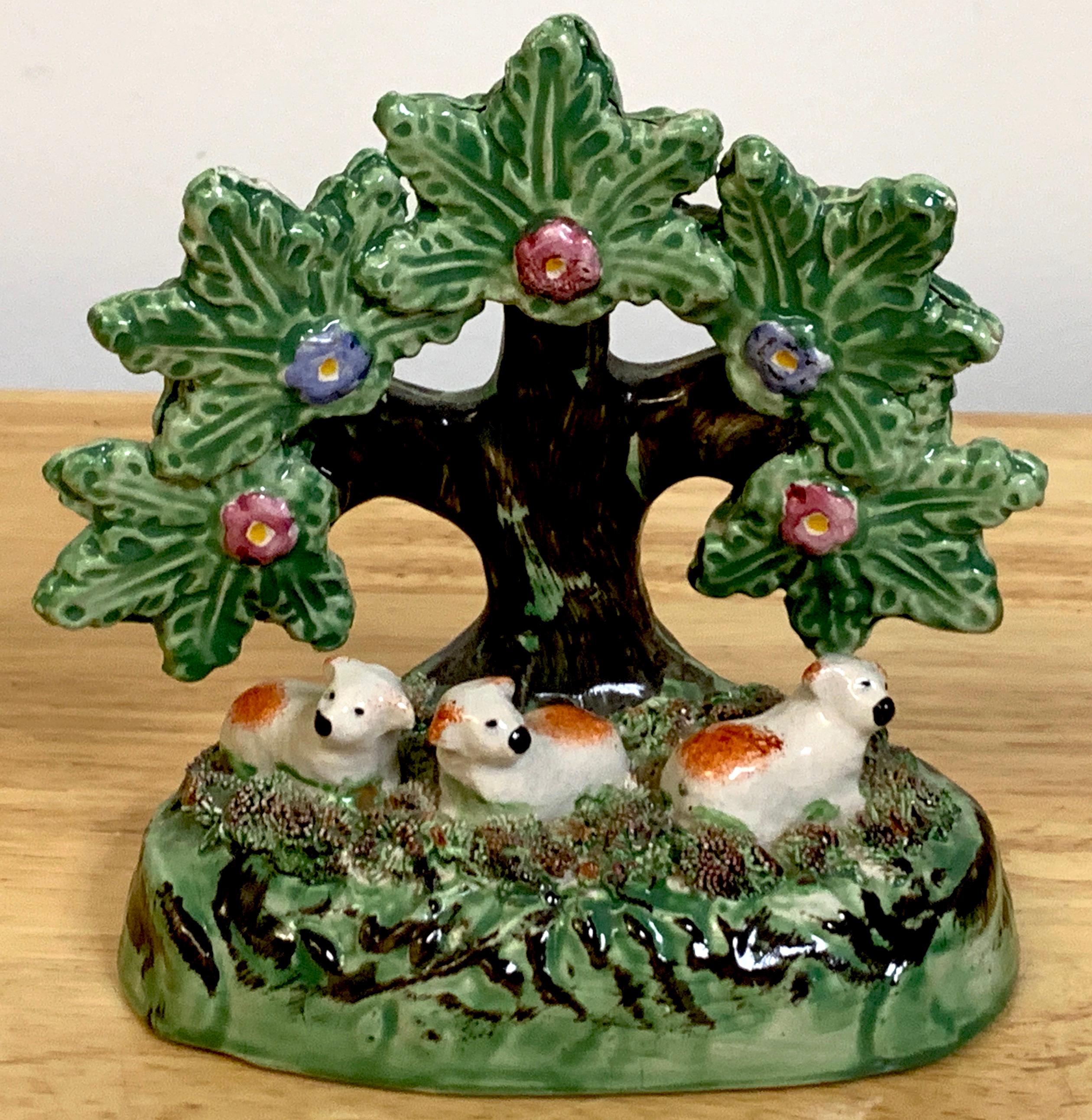 Staffordshire Pearlware bocage pack of red spaniel puppies or sheep- A rare whimsical grouping of three seated red and white animals under a tree on an oval naturalistic base.
     