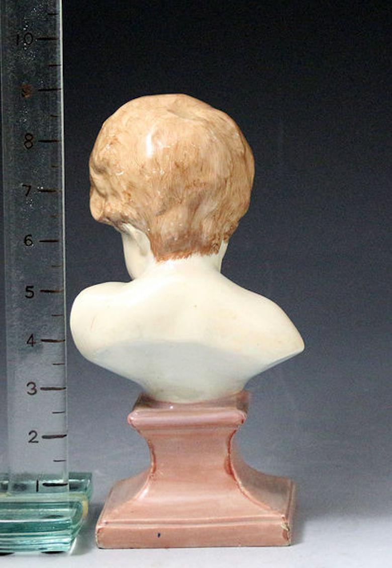 Staffordshire Pearlware Bust of a Putto on a Socle Base, Early 19th Century In Good Condition For Sale In Woodstock, OXFORDSHIRE