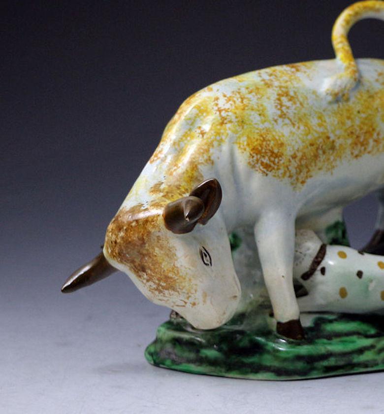 A well-modelled pottery figure of a bull and a bull terrier standing on a green base. The group is of a good size and proportion with a sculptural impact. Late 18th century.
 