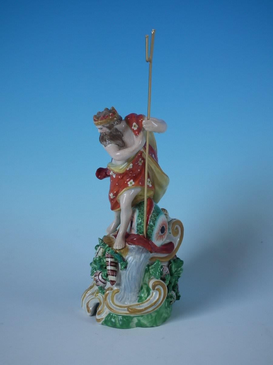 Staffordshire pottery pearlware figure with a mythological theme which features Neptune and a dolphin, stood on a rococo base. Decorated 'in the round' - decoration to front and reverse. Open bottomed. Maker's marks to the underside. Book reference,