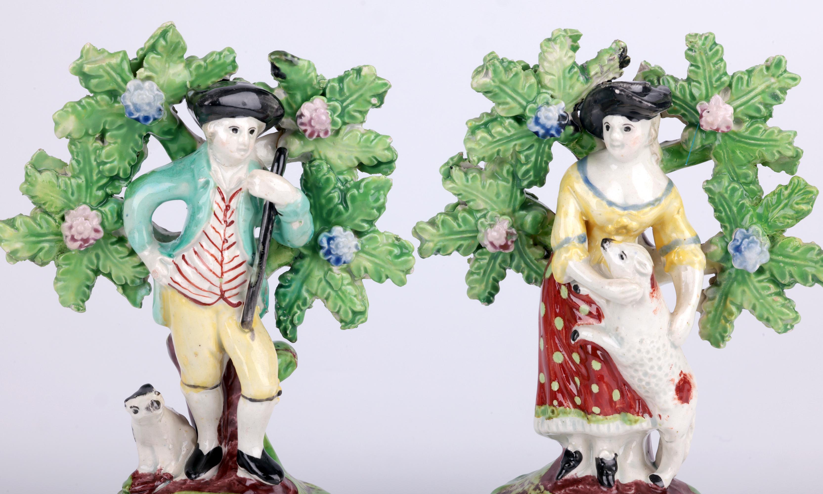 Ein entzückendes Paar antiker Staffordshire-Perlkeramikfiguren eines Hirten und einer Hirtin aus dem frühen 19. Jahrhundert. Die Figuren stehen erhöht auf einem abgerundeten, hohlen Sockel, die Fronten sind mit einem kleinen Blumenmuster über
