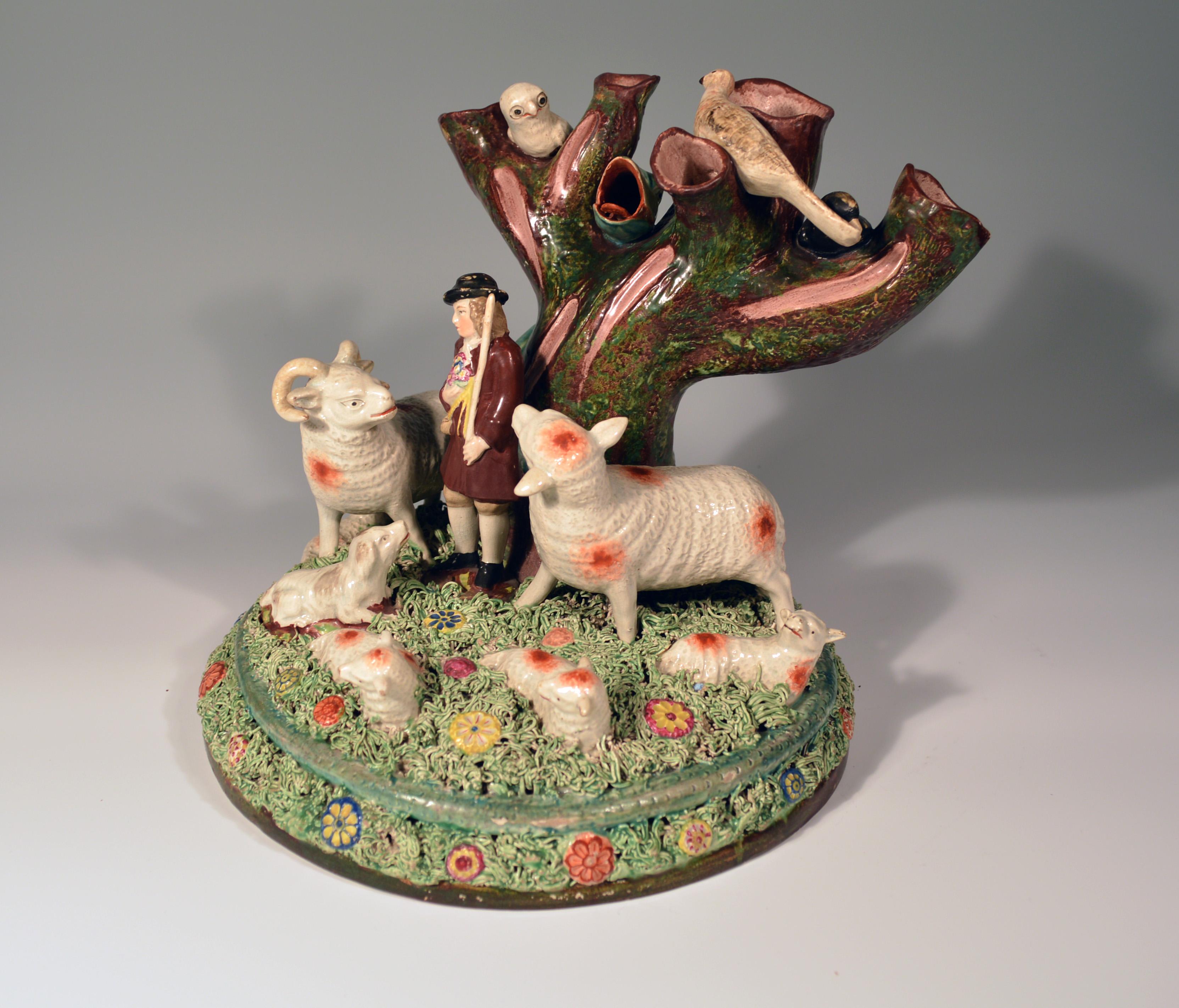 Staffordshire pearlware rare Pottery Group of Shepherd and Herd of Sheep, 
circa 1825

The extremely rare large figure group depicts a large central hollow tree at the back with three large oversized birds perched upon the thick branches, one of