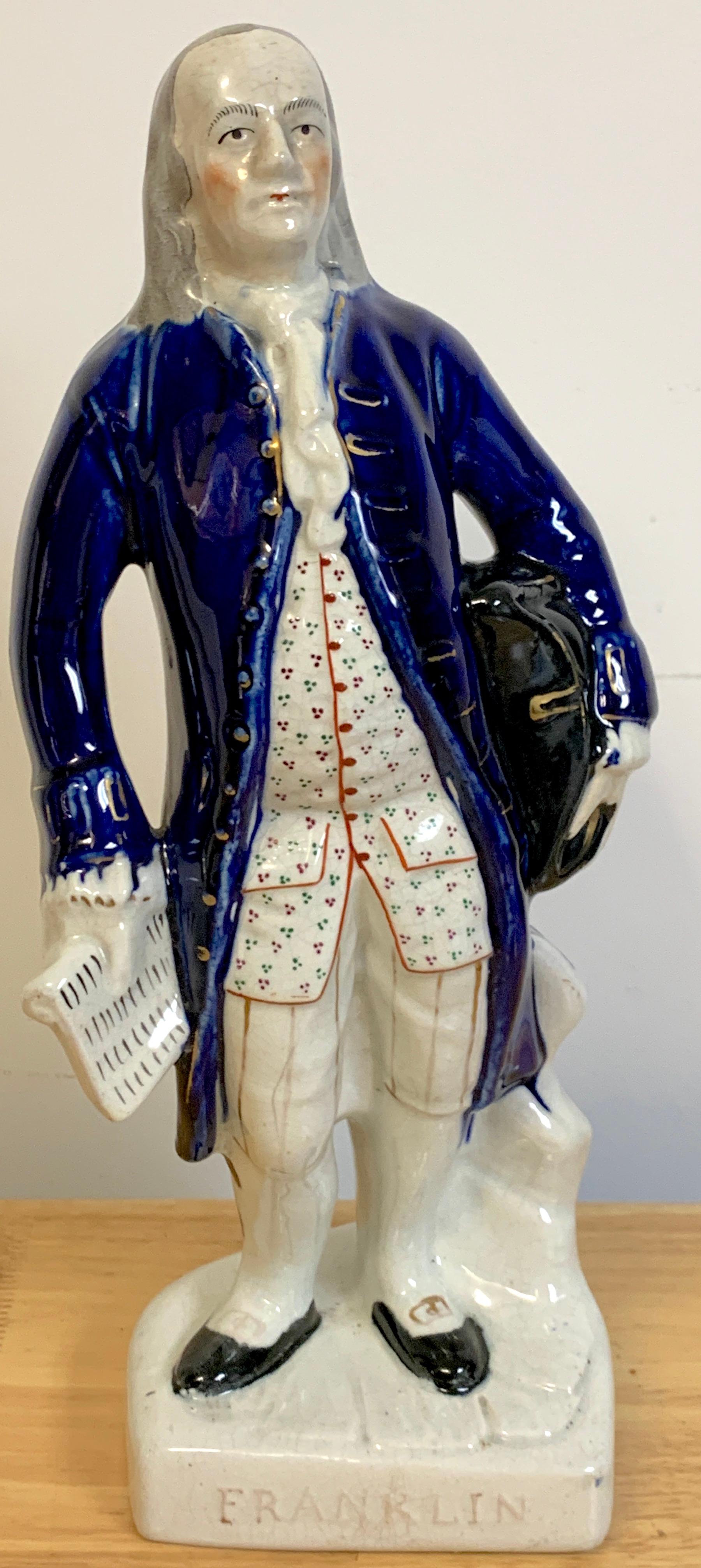 Staffordshire portrait figure of standing Franklin, Circa 1850
Depicting Ben Franklin before a tree-stump, holding a tricorne hat against his left hip, a document in his right hand, wearing a blue coat correctly titled FRANKLIN

Staff Franklin