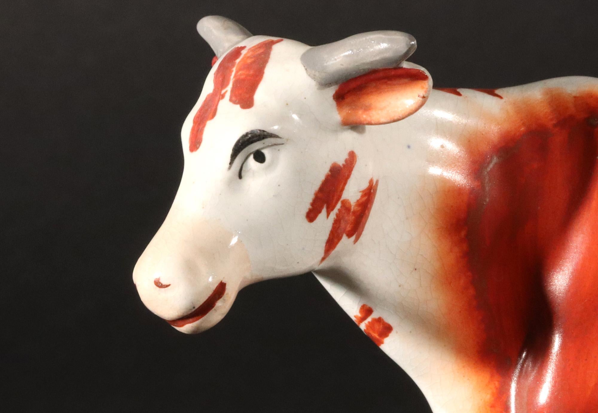 Figura de vaca de cerámica de Staffordshire con lechera
Alrededor de 1860-80

El gran modelo de cerámica de Staffordshire representa una gran vaca con una lechera sentada en un taburete con un cubo de leche delante de ella y debajo de la vaca.  La