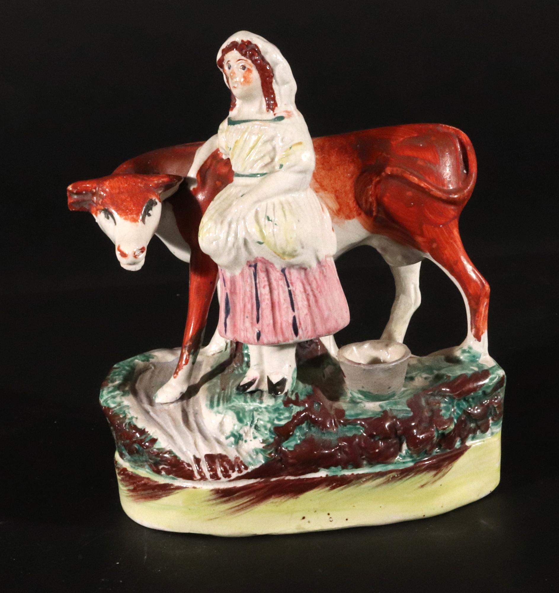Staffordshire Pottery Cow Figure with Milkmaid,
Circa 1860

The Staffordshire pottery model depicts a cow crossing a small stream.  By her side is a milkmaid stand by the cows head and with her right arm resting upon the cow's back.  Behind her sits