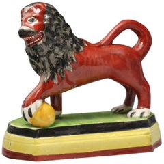 Antique Staffordshire Pottery Figure of a Lion with Paw on Ball, Early 19th Century