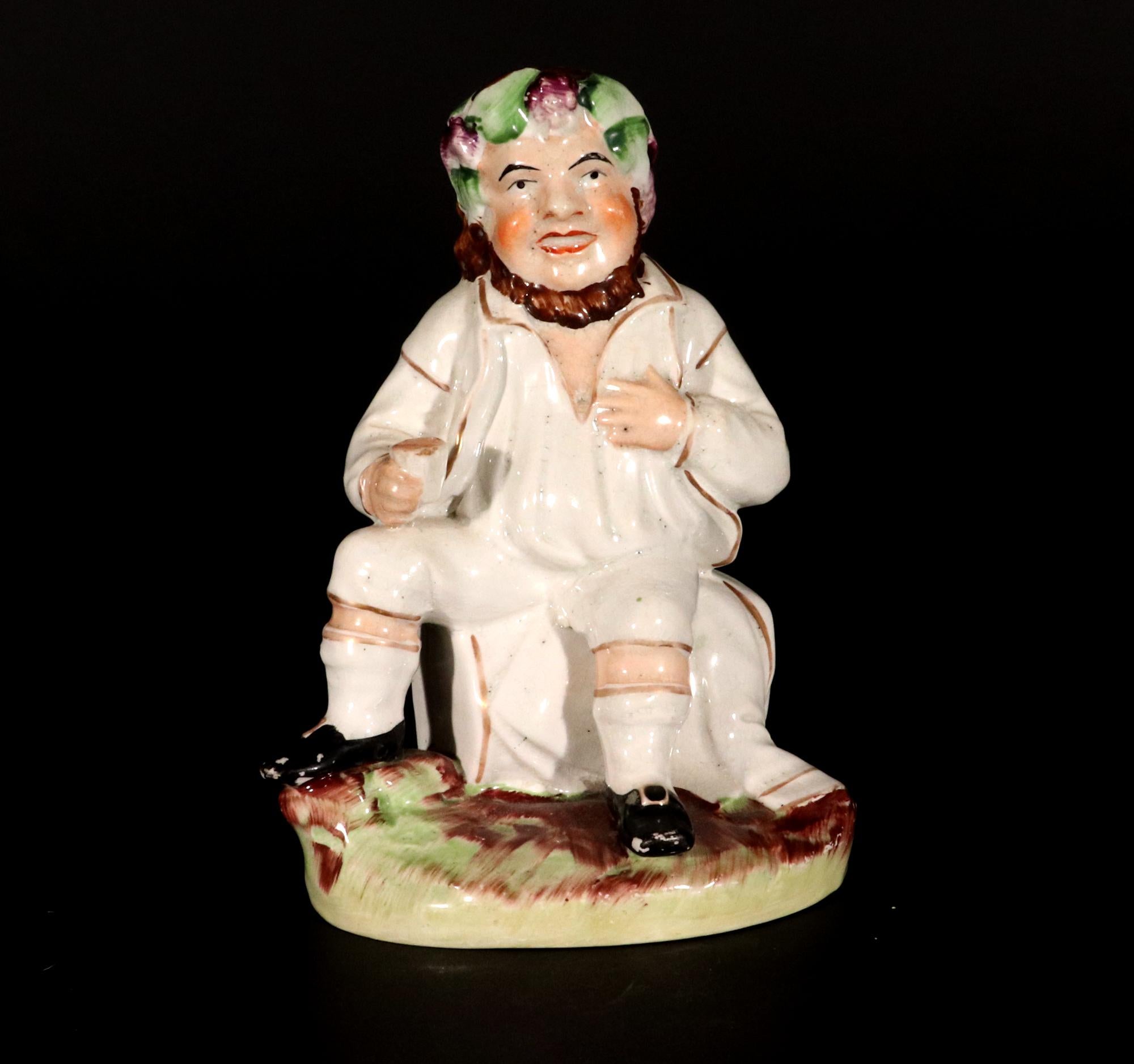 Staffordshire Pottery Figure of Bacchus With Cup on a Wine Barrel,
19th Century

The charming figure depicts the figure of Bacchus with a grape and leaf wreath around his head sitting on a wine barrel with his right left raised on a grassy mound. 
