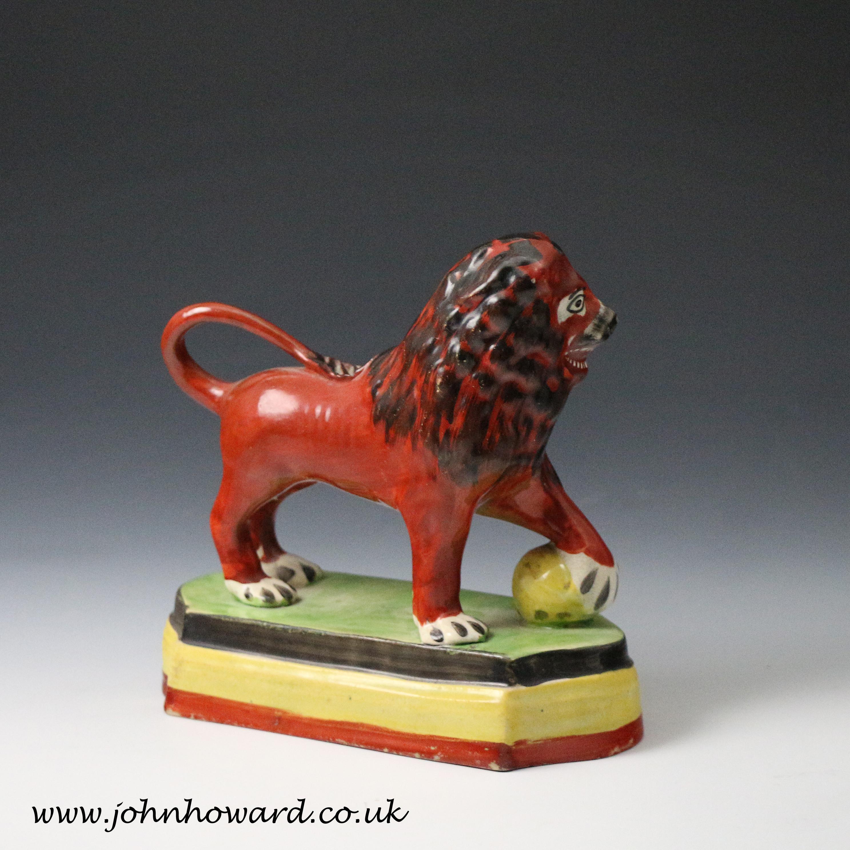 Dated: 1820 Staffordshire, England

A Staffordshire pottery pearlware figure of a lion with a paw resting on a yellow ball. The lion sports an alarmingly vicious set of teeth which has a particular comedy within the fierceness. The rectangular