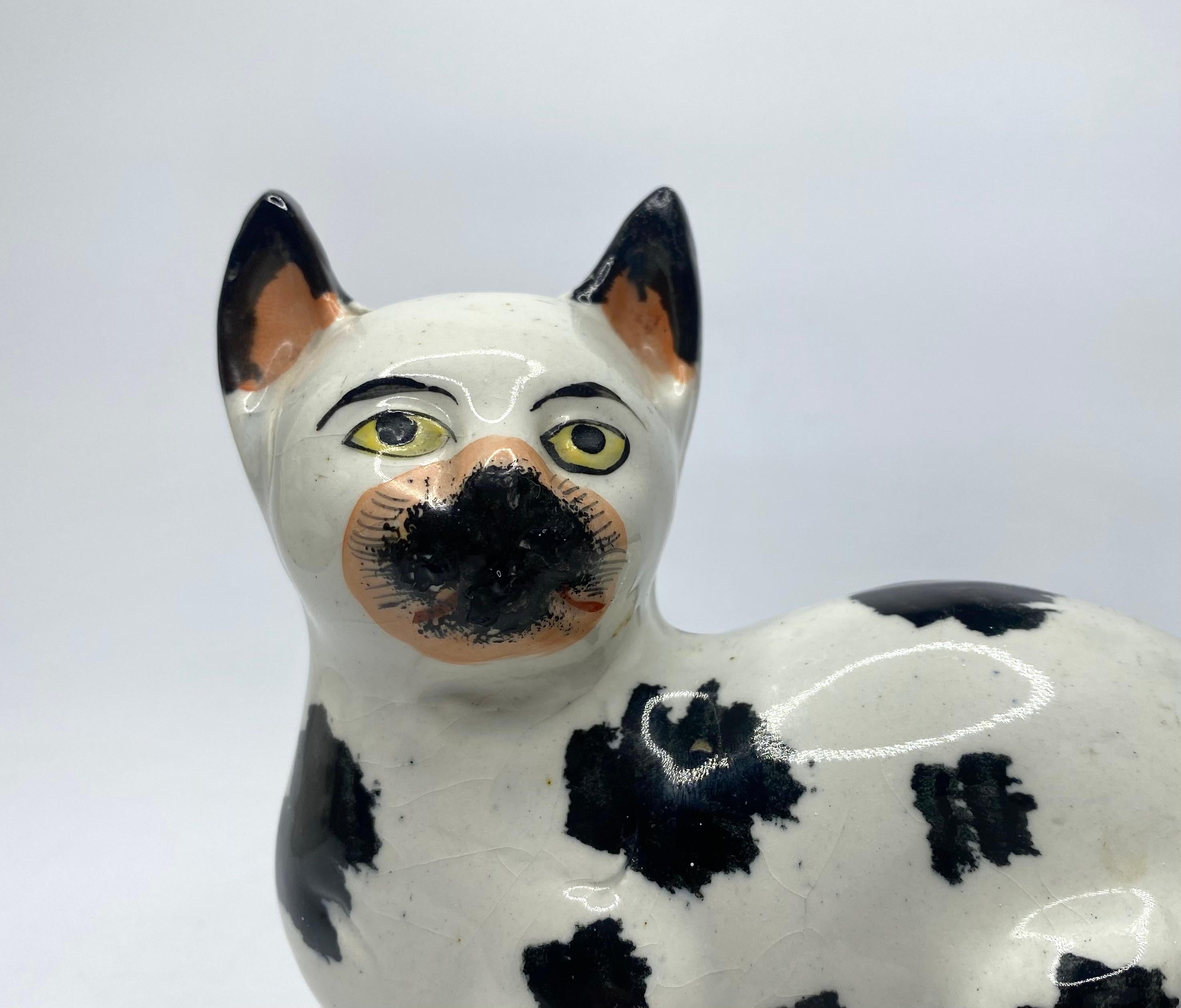 Fired Staffordshire pottery recumbent cat, c. 1850. For Sale