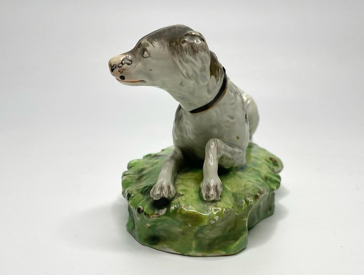 Staffordshire pottery pearlware figure of a Setter, Enoch Wood factory, c. 1820. Finely modelled as a recumbent Setter, upon a grassy mound base. The hound, painted with black hair, and wearing a collar.
Length – 16 cm, 6 1/4”.
Height – 9.5 cm, 3