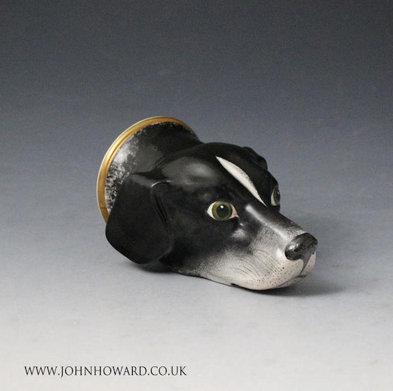 Dated: 1825 Staffordshire England UK

A Staffordshire pottery stirrup cup in the form of a hounds head. The dog is painted with realism and character, a very expressive example. The model sits on the flat chin and the rim is enhanced with a gilt