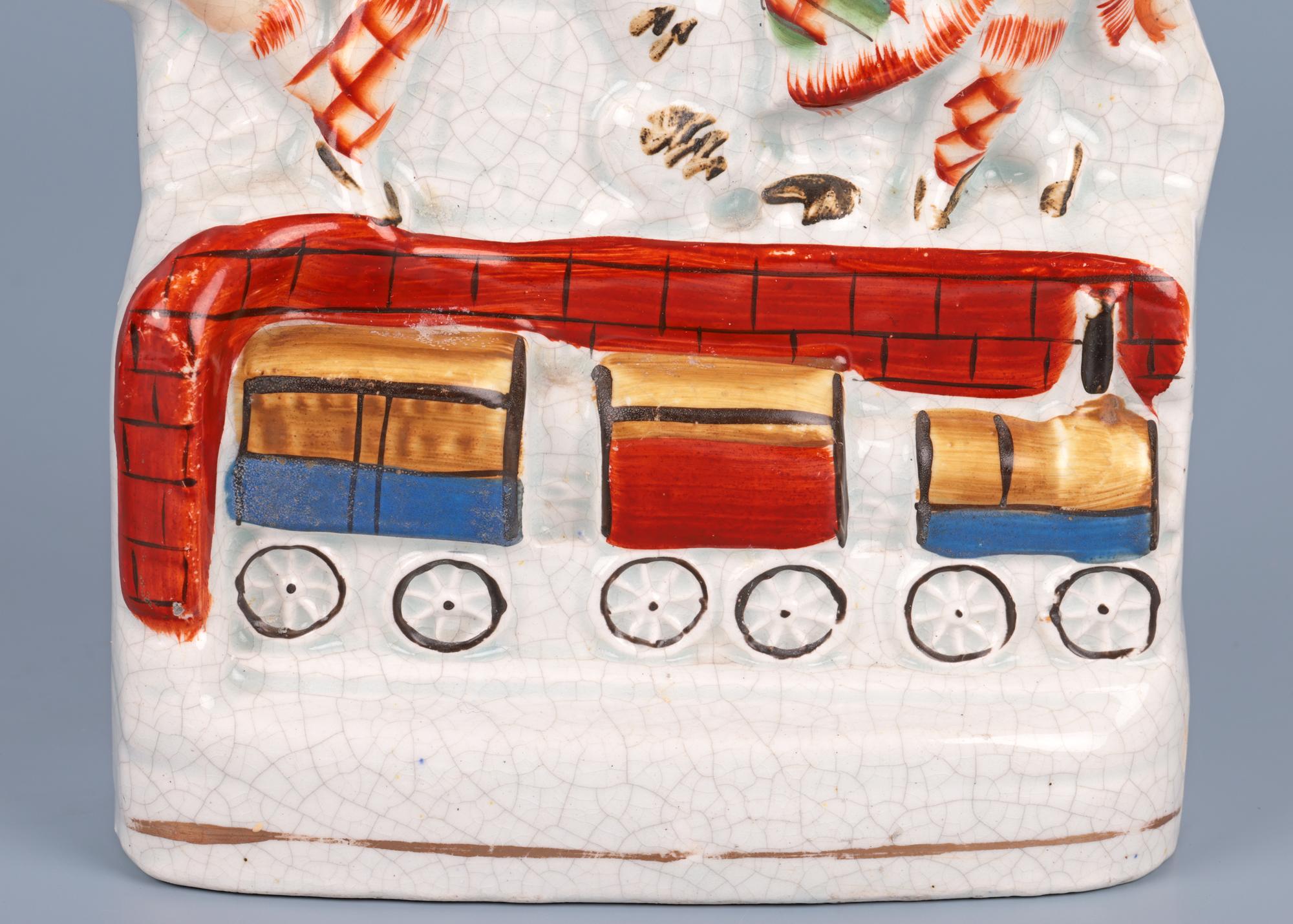 Rare vase à déversement en poterie anglaise Staffordshire à fond plat représentant un couple assis avec un chien et un exemple évolué de la Fusée de Stephenson datant du 19e siècle et présentant un intérêt pour les chemins de fer. Le vase à