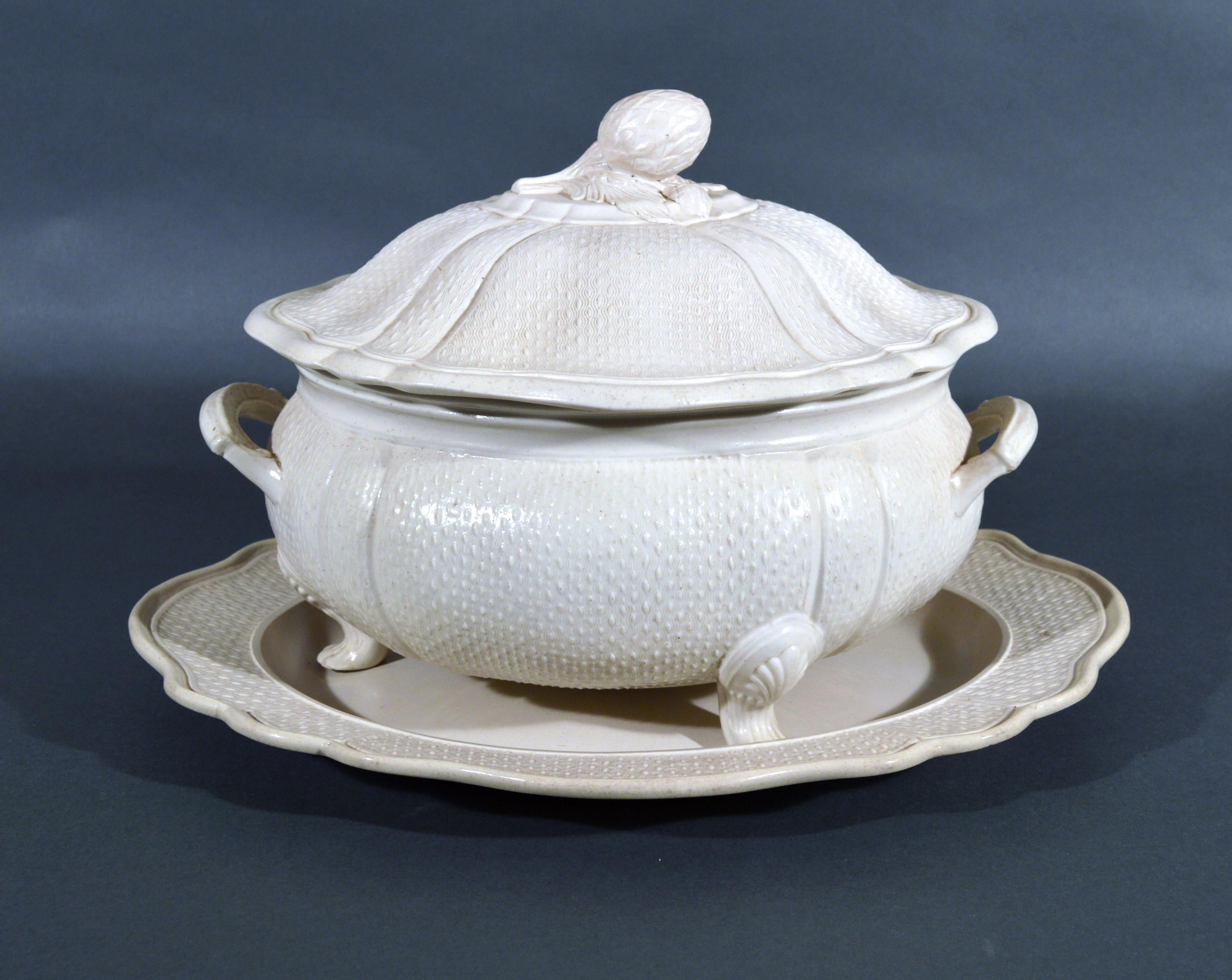 Staffordshire saltglaze stoneware soup tureen, cover and stand,
circa 1760
   
A large plain salt-glazed stoneware soup tureen, cover and stand with molded barley corn or seed design raised on three claw feet with top molded with a large leaf.