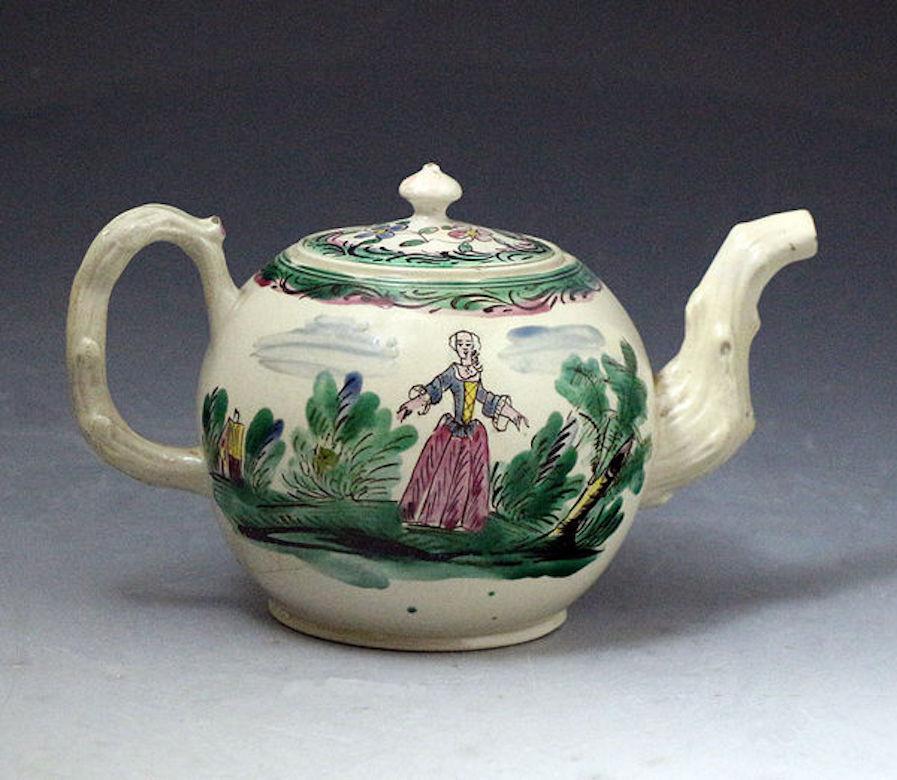 Staffordshire stoneware salt glazed teapot color decorated with male and female figures, mid-18th century. Staffordshire, England, 1760.

Salt-glazed stoneware teapot colored, decorated with a male figure playing the flute standing against trees,