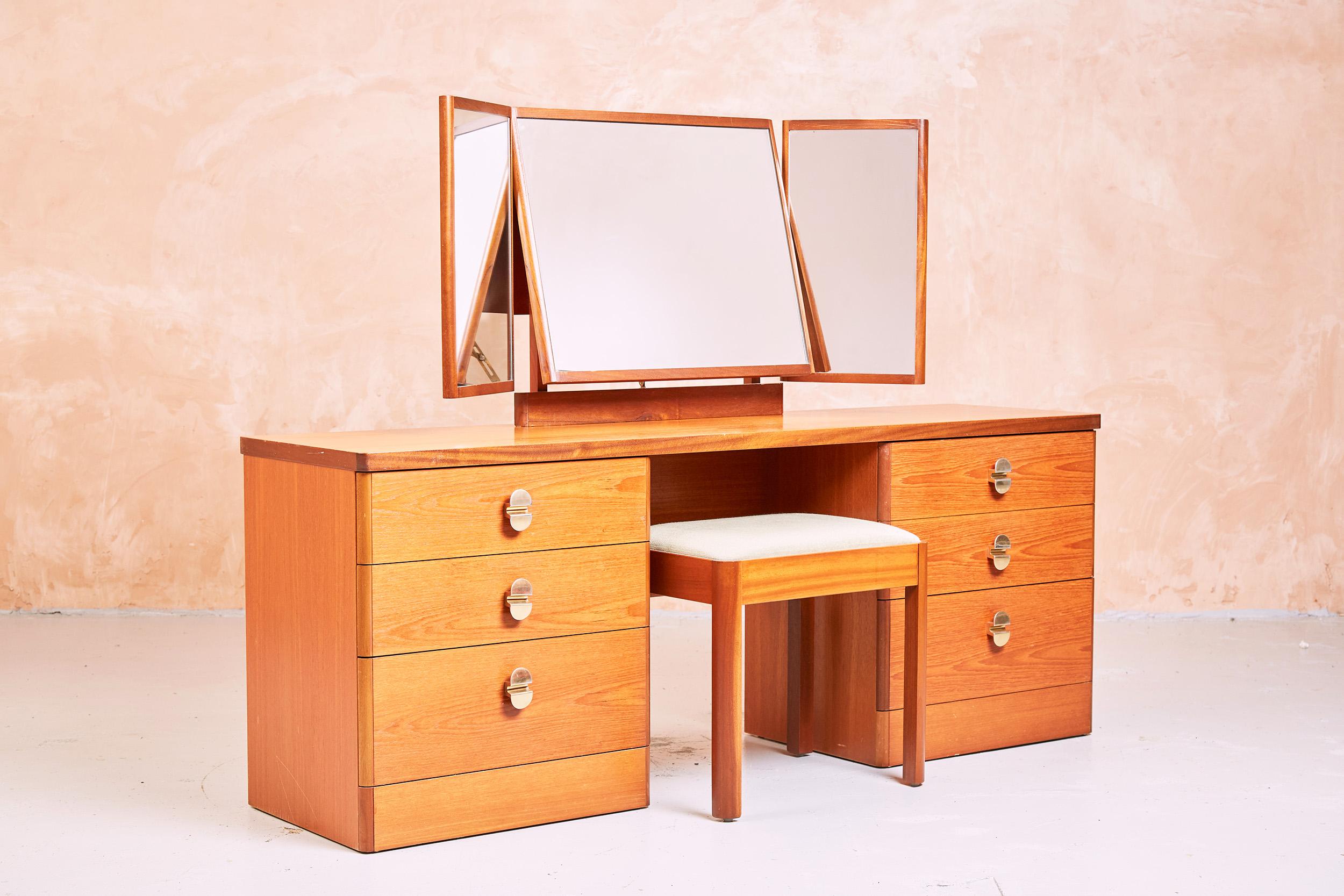 Mid Century Teak Stag Cantata Dressing Table with Brass Handles and a stool

This is an excellent piece of furniture from the well known and respected manufacturer Stag.

As with all furniture produced by Stag this is a well made piece and is from