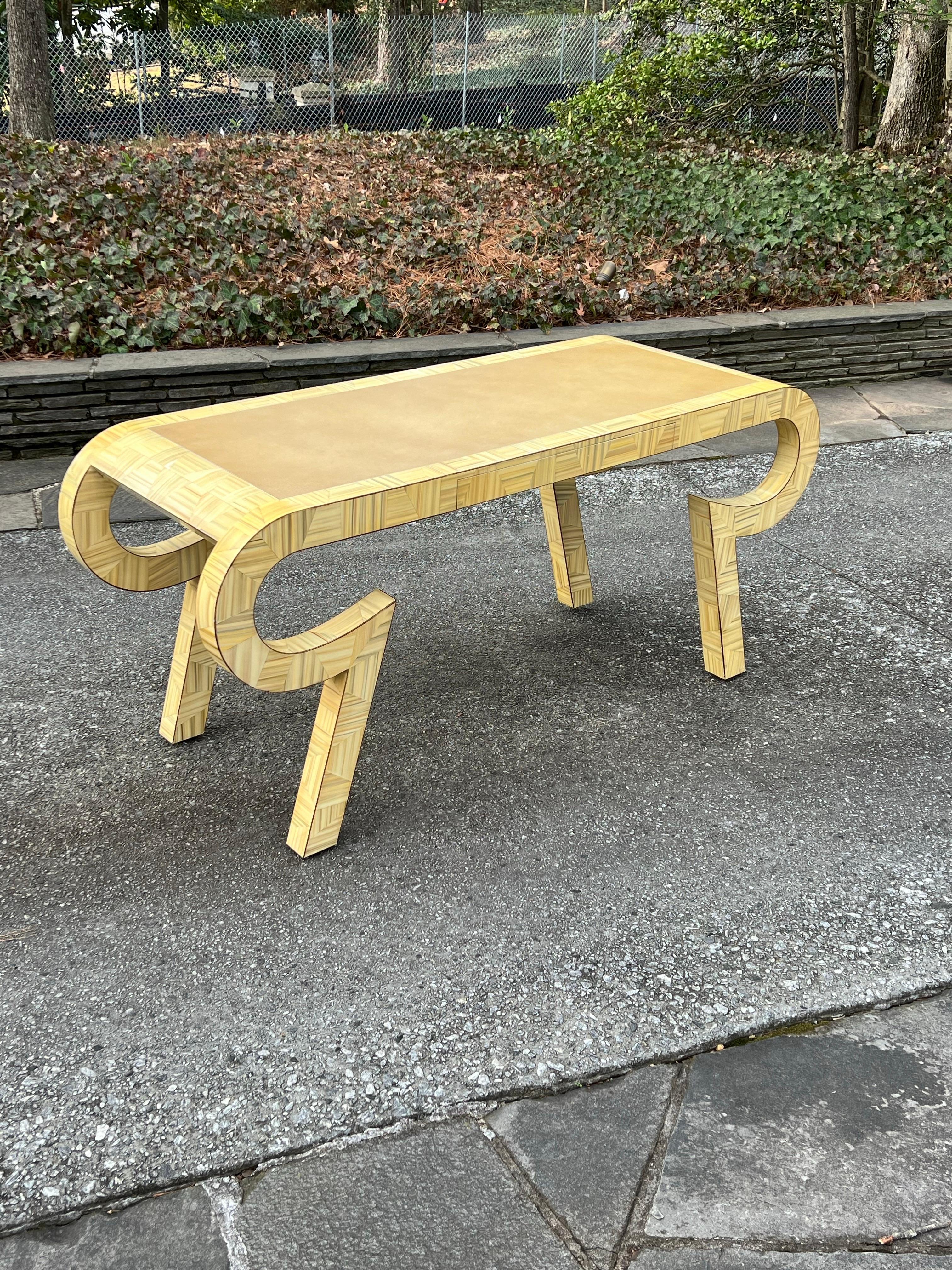 Una asombrosa consola o escritorio de la producción limitada de muebles diseñados por Alessandro Gambrielli para Baker, Italia, hacia 1980. Preciosa forma robusta de madera dura, pintada a mano y acabada en laca. Parte superior de cuero. Una obra de