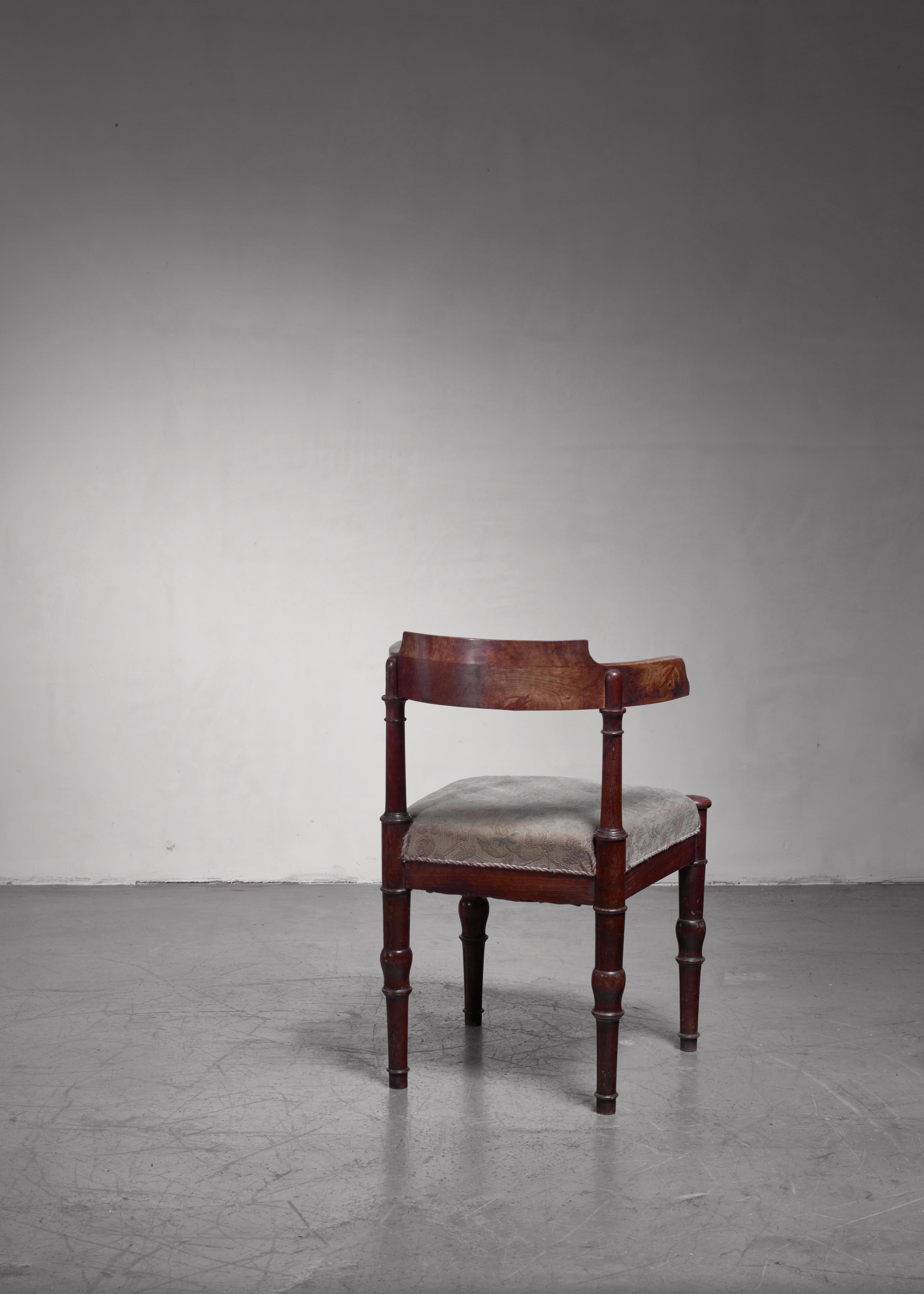 An early 20th century Danish artist chair made of stained beech with a seat upholstered with patterned fabric. The chair has sculpted feet and a wonderful, curved backrest.