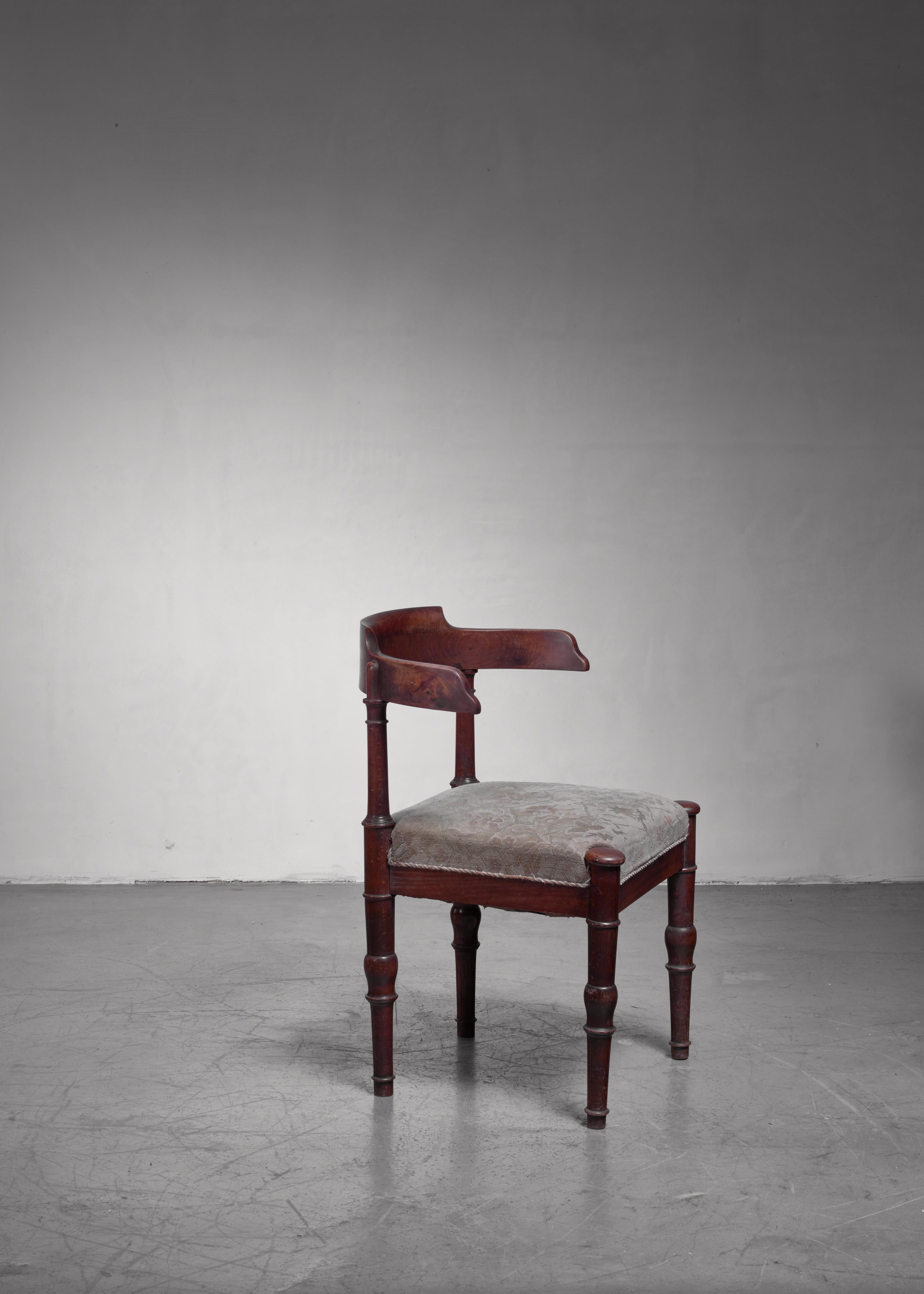 An early 20th century Danish artist chair made of stained beech with a seat upholstered with patterned fabric. The chair has sculpted feet and a wonderful, curved backrest.
