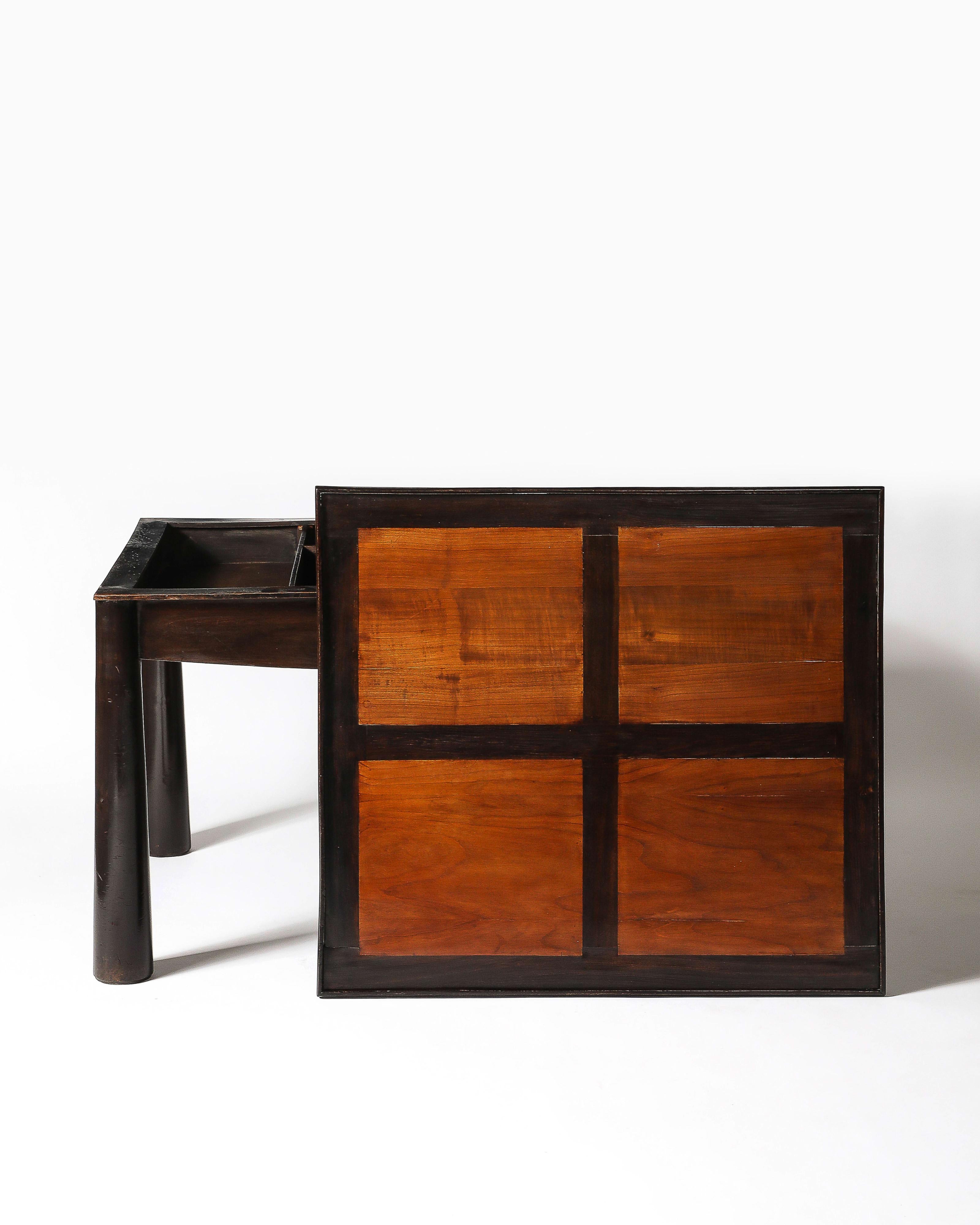 Modernist games table with substantial legs and a thoughtfully constructed top; the curved apron hides segmented storage.