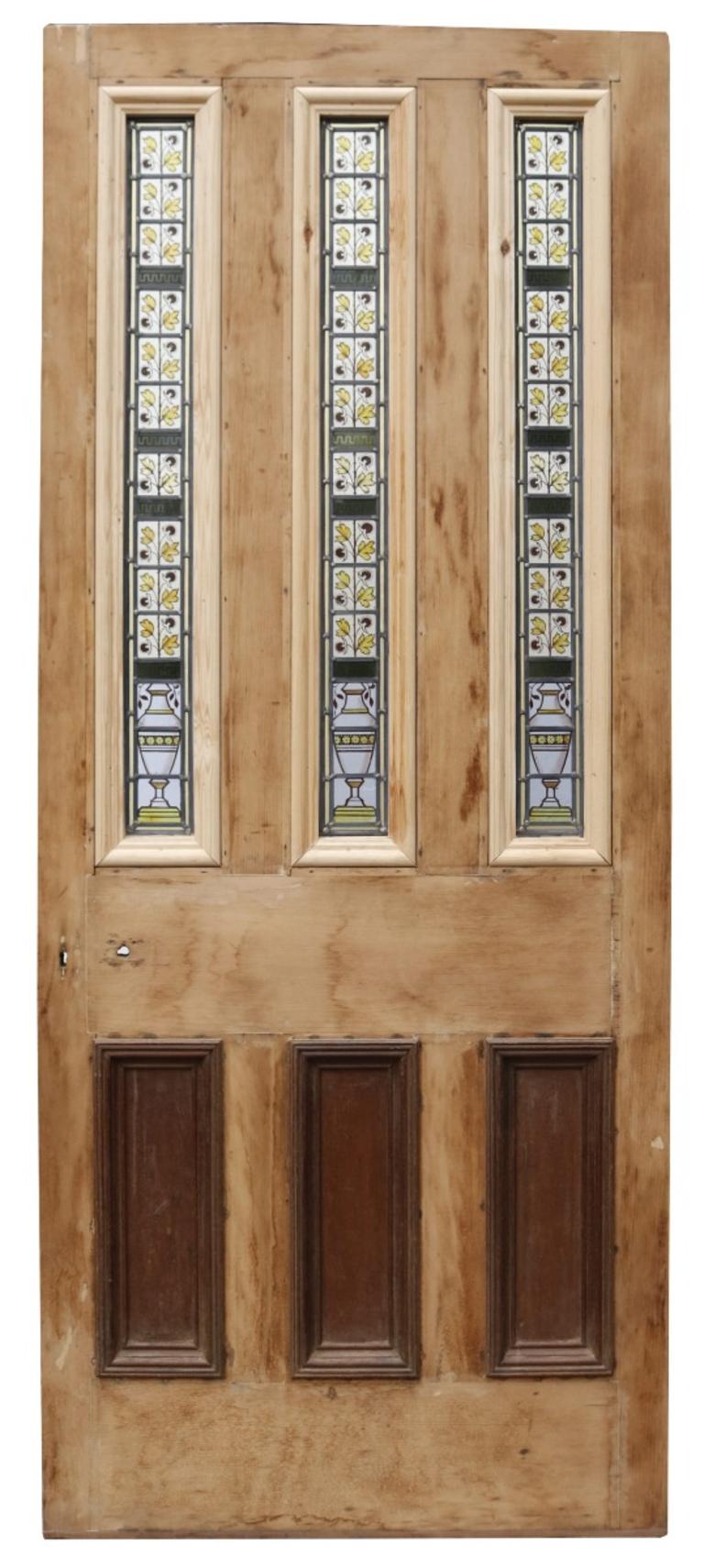 A reclaimed stained glass exterior door featuring three vertical glazed panelling with urns and foliage.