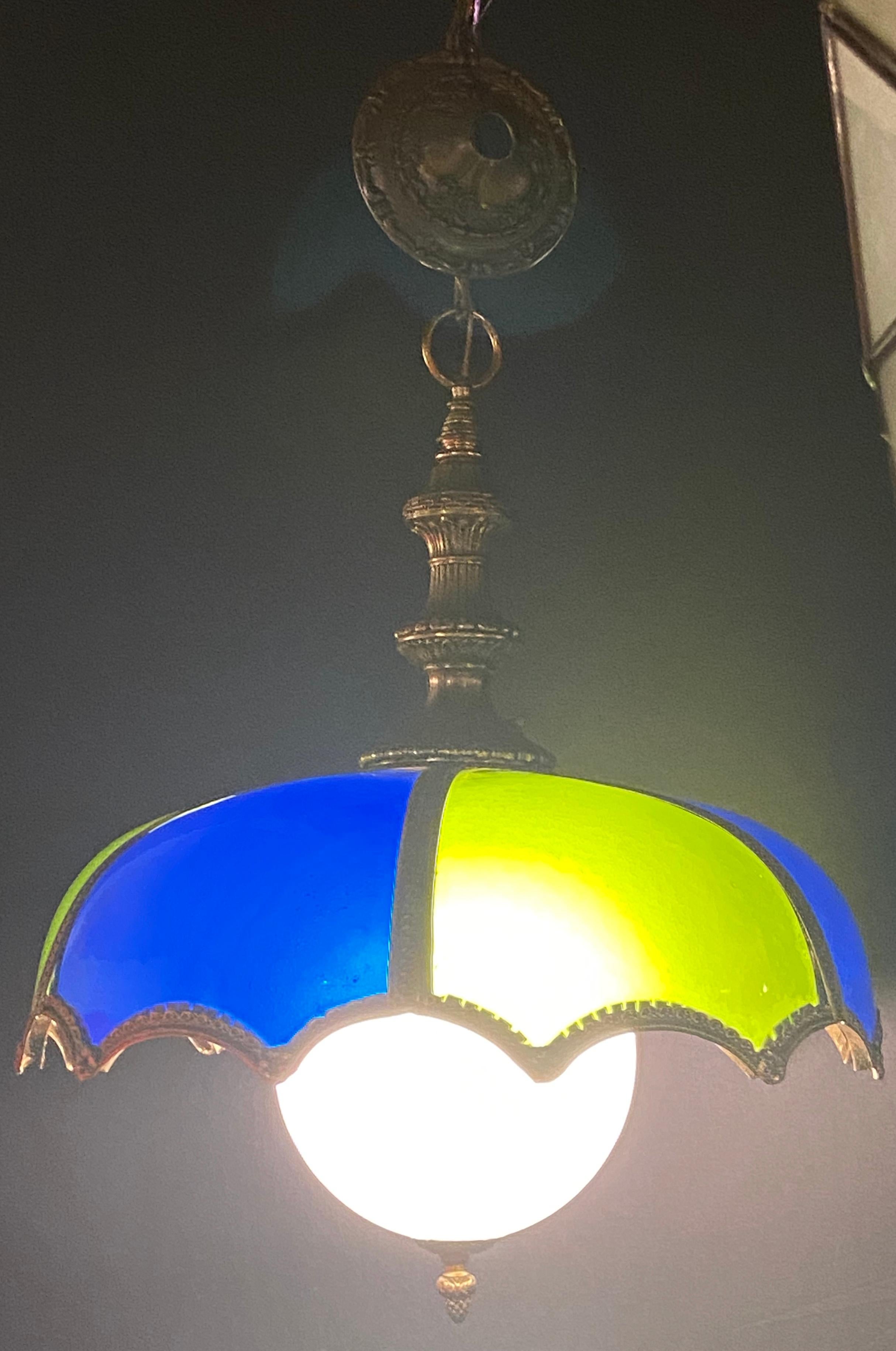 Stained glass dome shaped bronze framed MCM Italian light with canopy

A stylish blue and green stained glass and bronze framed Italian chandelier or pendant. The chandelier features a dome shaped and bronze canopy. It will hang beautifully on
