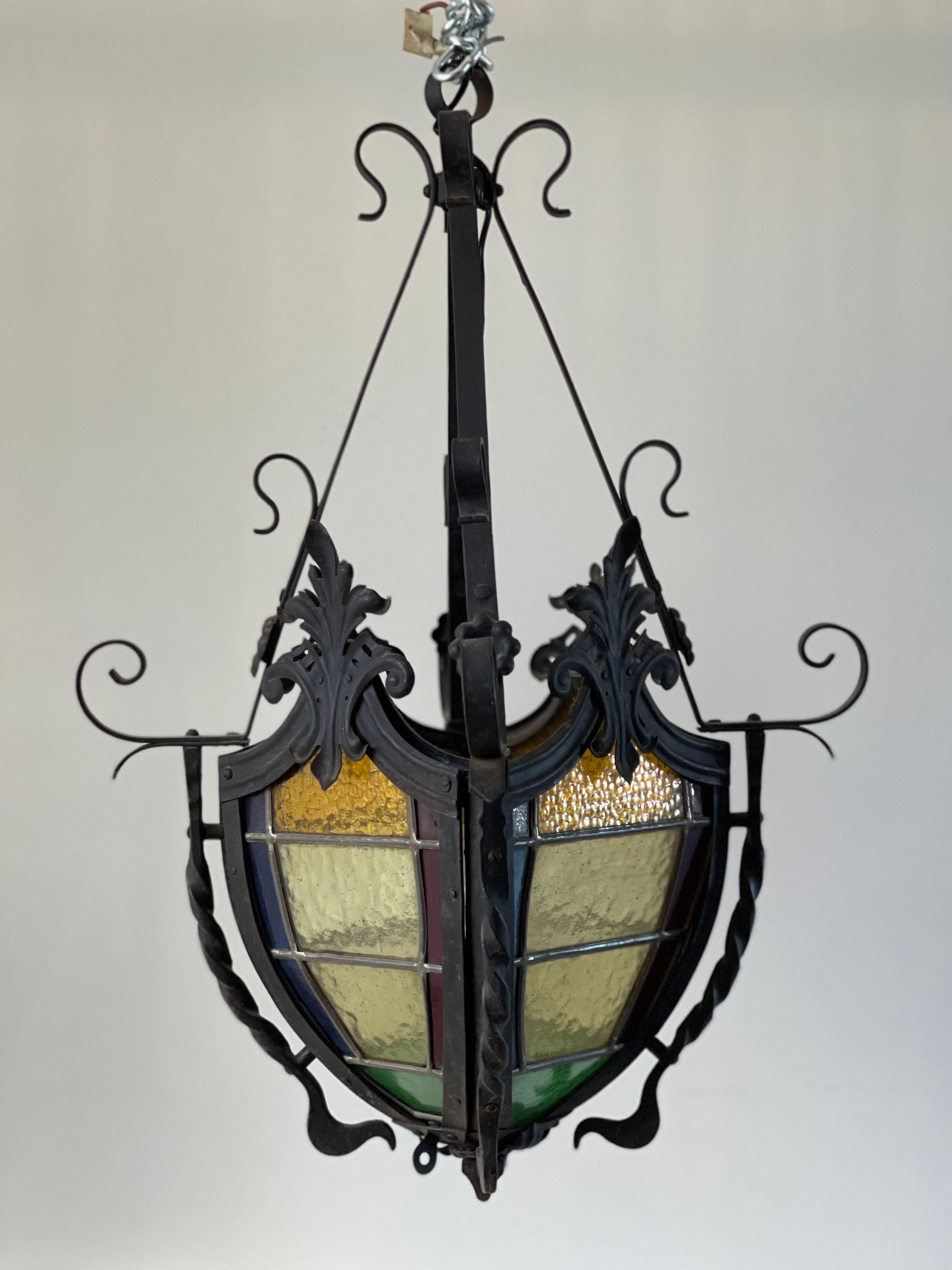 Wrought iron lantern with four faces in stained glass.