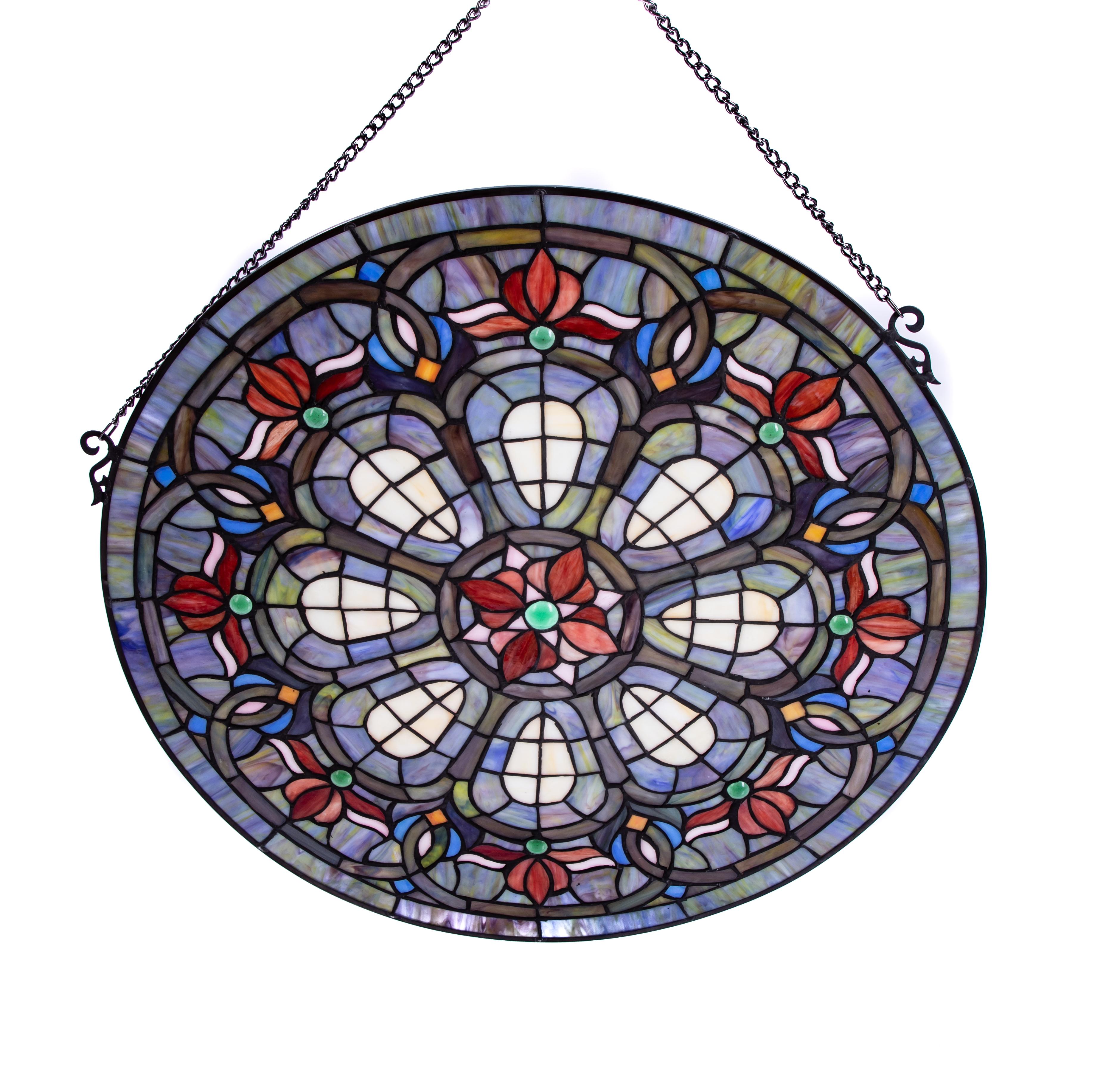Offering this stunning stained glass panel on chain. Round in shape with various colors and pattern. The majority of the piece is in blues. Also has many shades of green, red, and white. Having a floral and geometric feel this piece will not