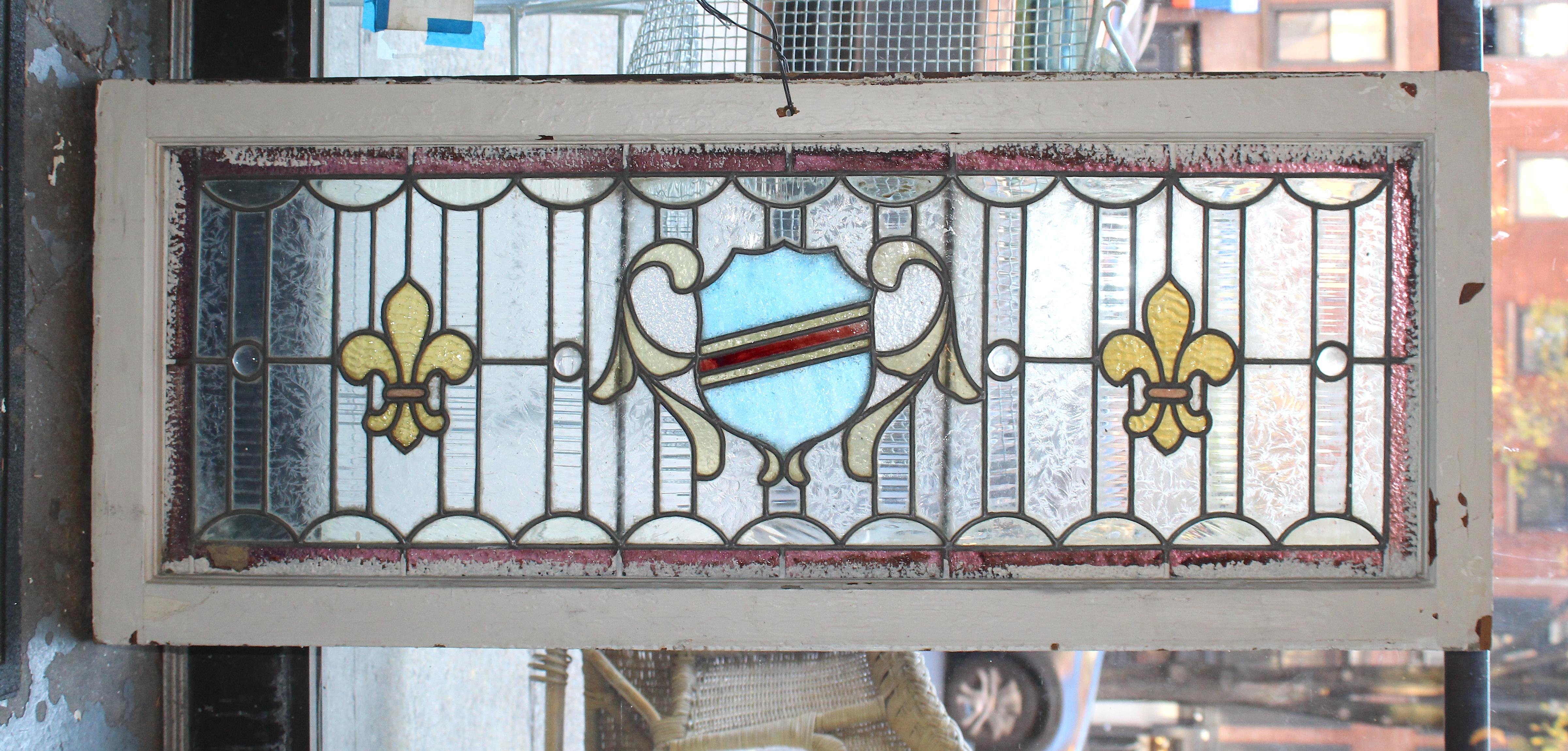 Long American made stained glass window with fleur-de-lis and shield.
Currently housed in a wooden frame - the overall dimensions are for the stained glass and the frame.
Located in NY