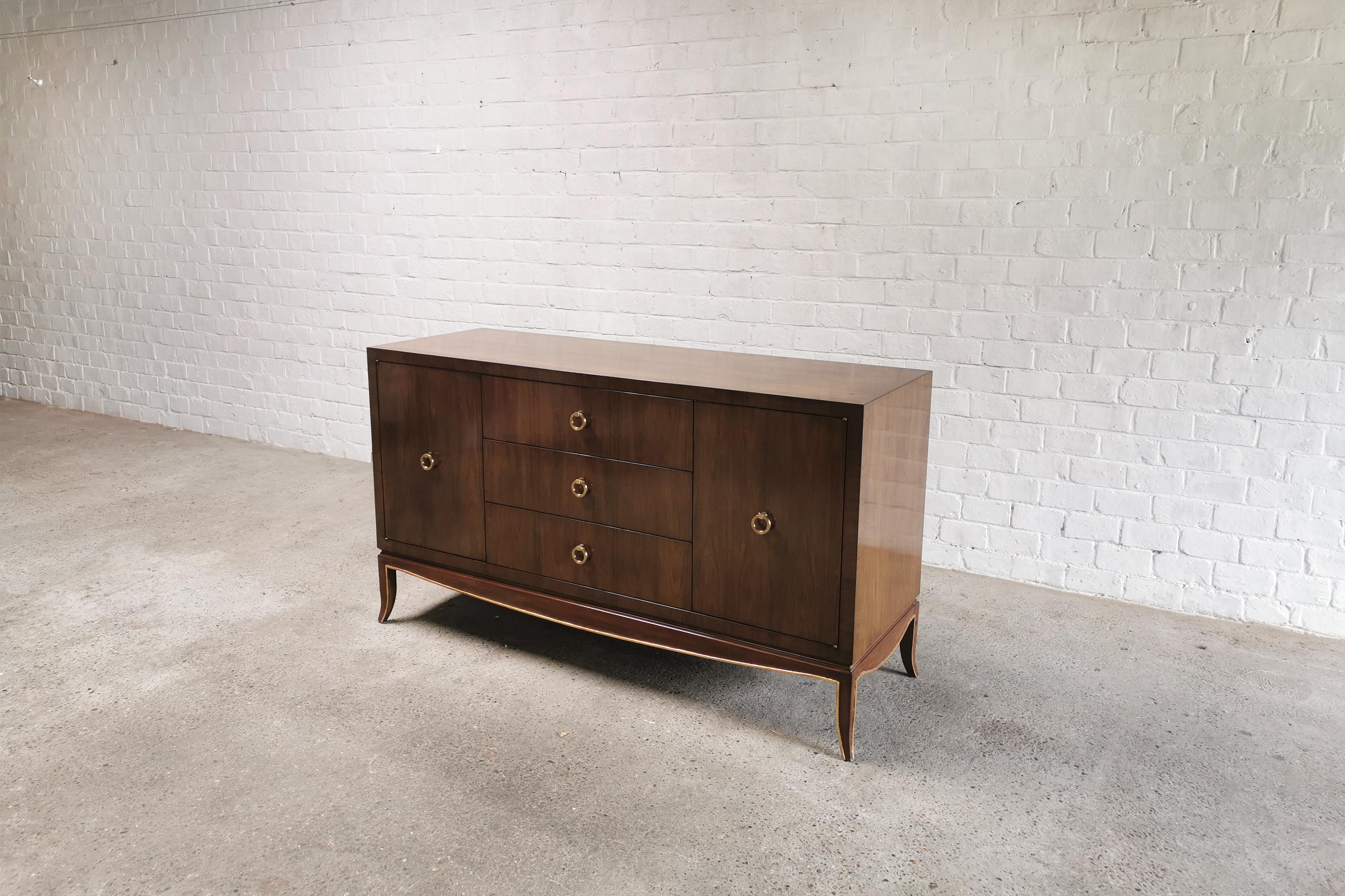 A french stained mahagony sideboard with brass handles, work from the late 20th century. The design is clearly a nod to Jules Leleu's designs and to the Art-Deco period of the 1920's. Impeccable qualitative craftmanship with a beautiful shine to the