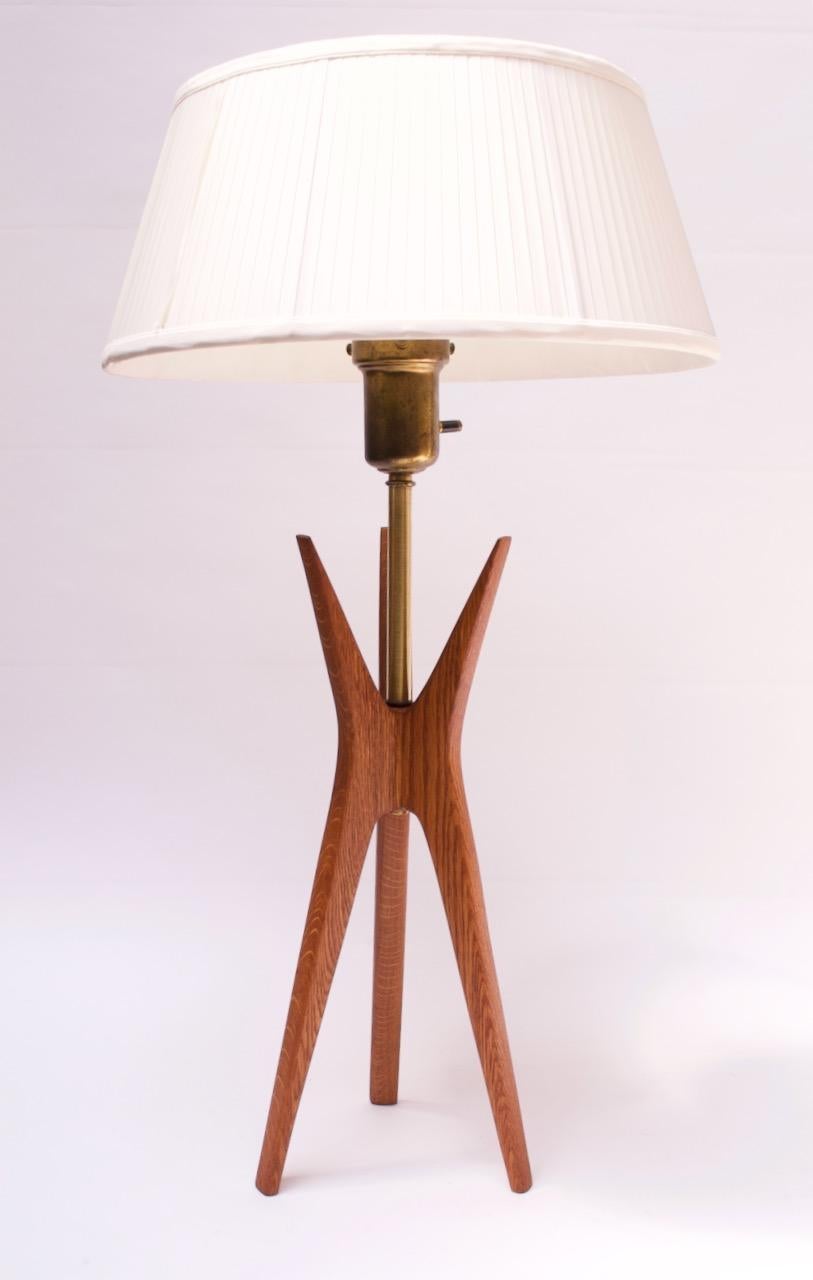 Atomic-style table lamp designed by Gerald Thurston, circa 1950s. Sculptural tripod base in stained oak with brass stem and original milk glass diffuser. The vintage linen shade shown has been added and shares similar form and dimensions as the