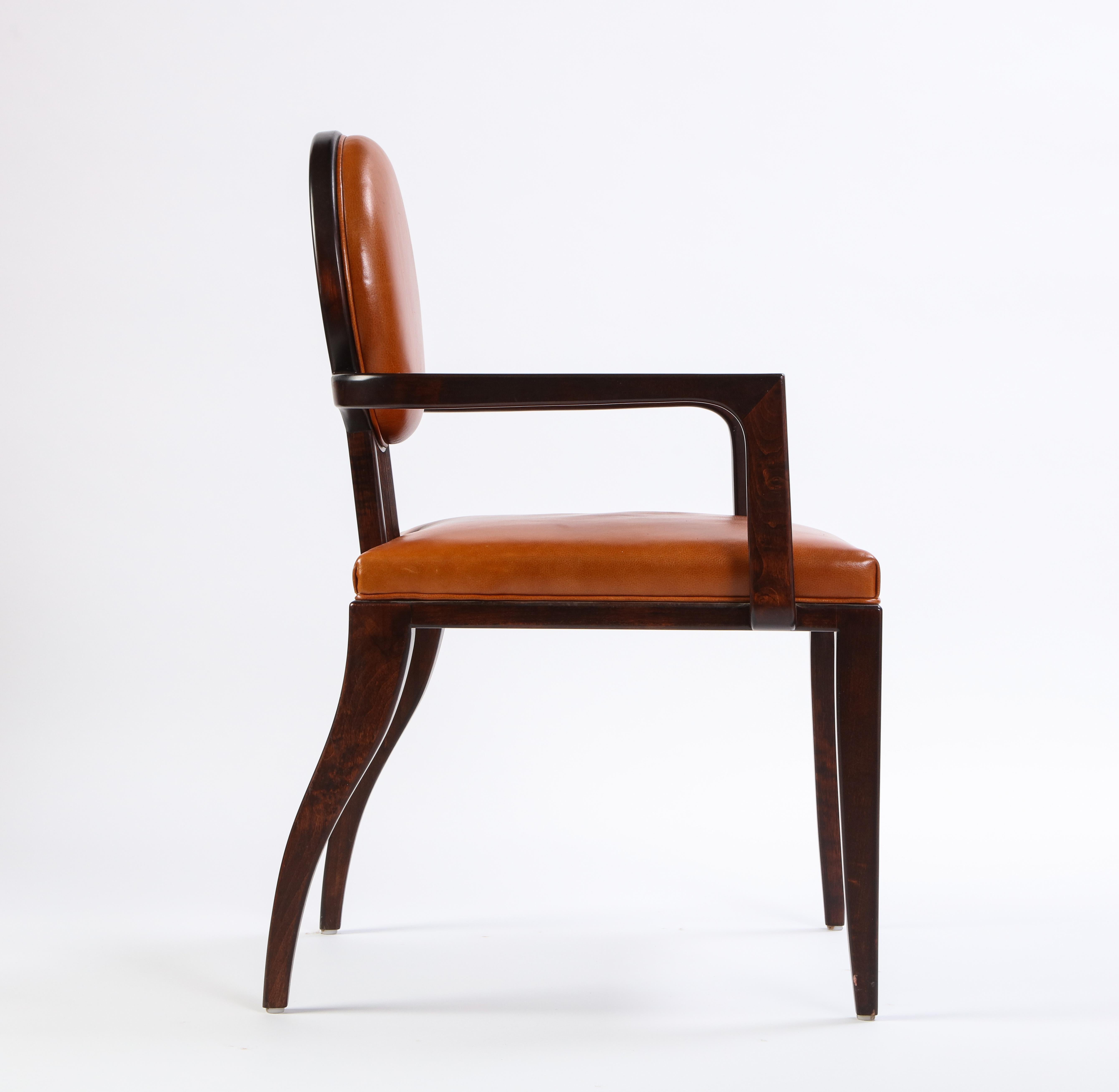 Designed by famed Juan Montoya, this modern armchair has beautifully stained wood and comfortable leather upholstery. Structurally sound and ready to place, this reads as a simple, yet striking, undeniably art deco accent piece. Collectors and