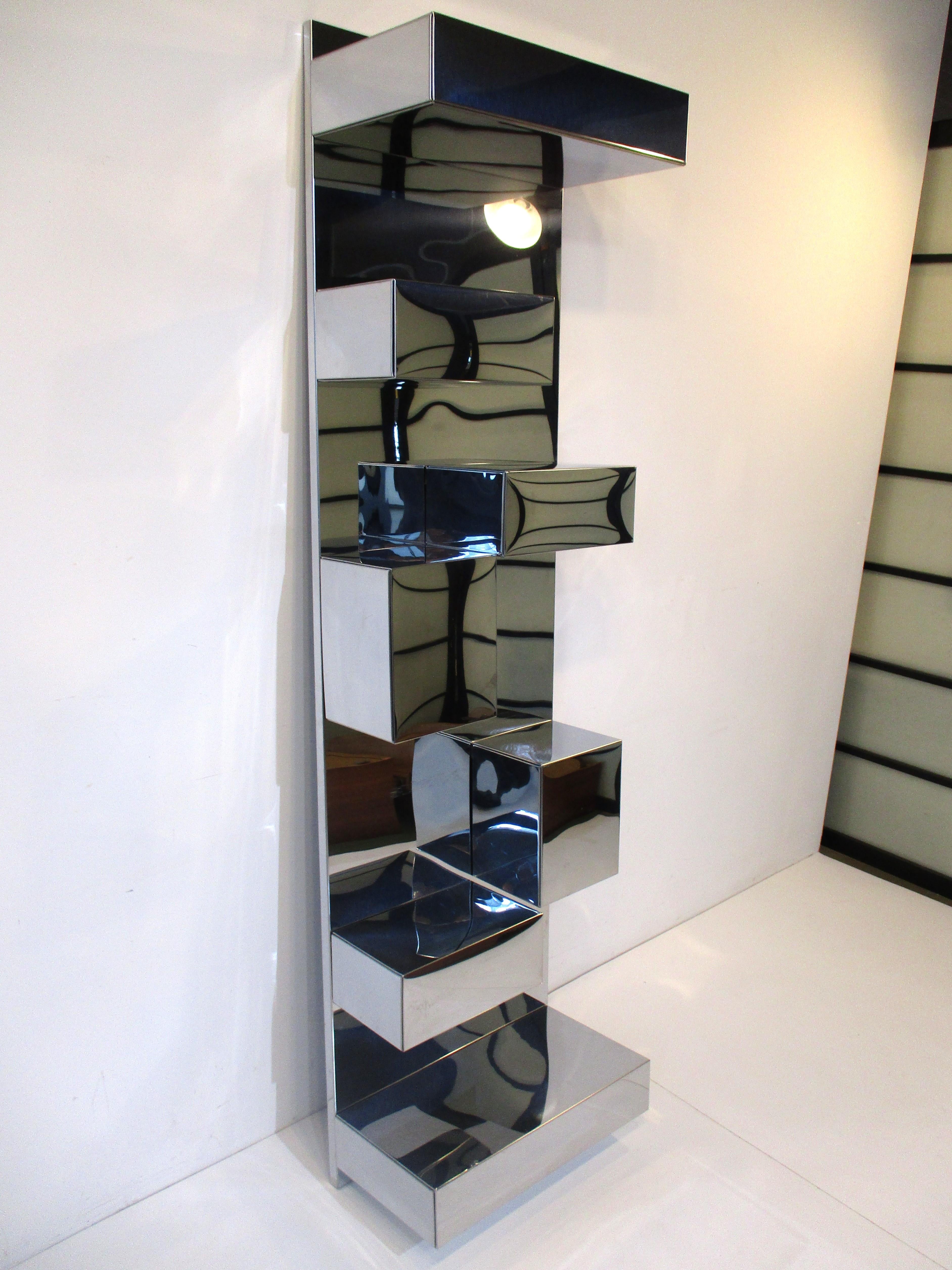 A very well crafted wall mounted shelving unit with seven removable box shelves and wall backing panel. The backing piece is wood and has polished stainless formed over it, this piece is attached to the wall. The horizontal box shelves slip over
