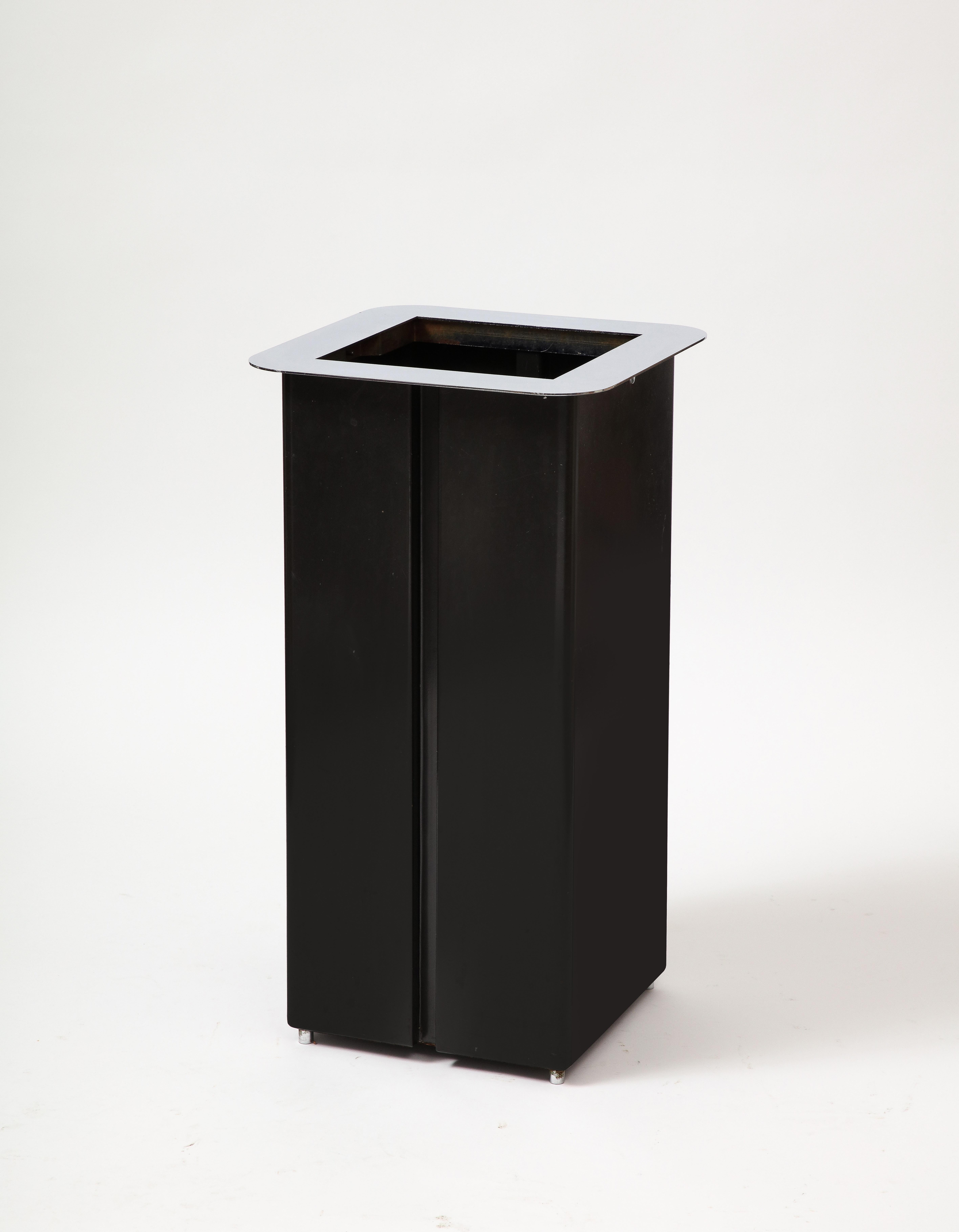 Portaombrelli moderno con piano cromato e corpo in acciaio sagomato e scurito.