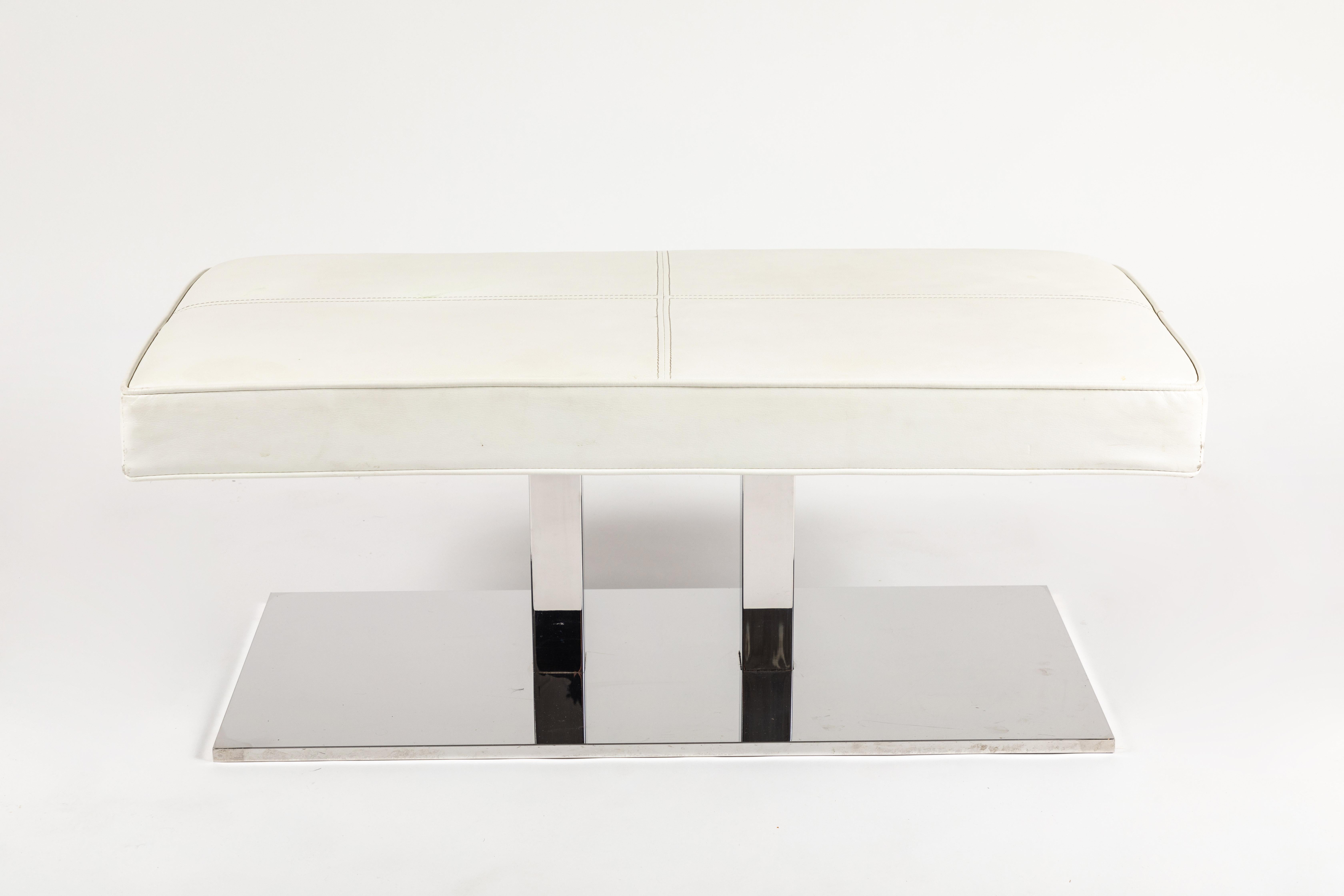 A chic and modern bench designed by Philippe Starck for the SLS hotel in Los Angeles. A highly polished stainless steel base with 2 vertical risers that support the original white faux leather seat featuring baseball stitched details. The seat is