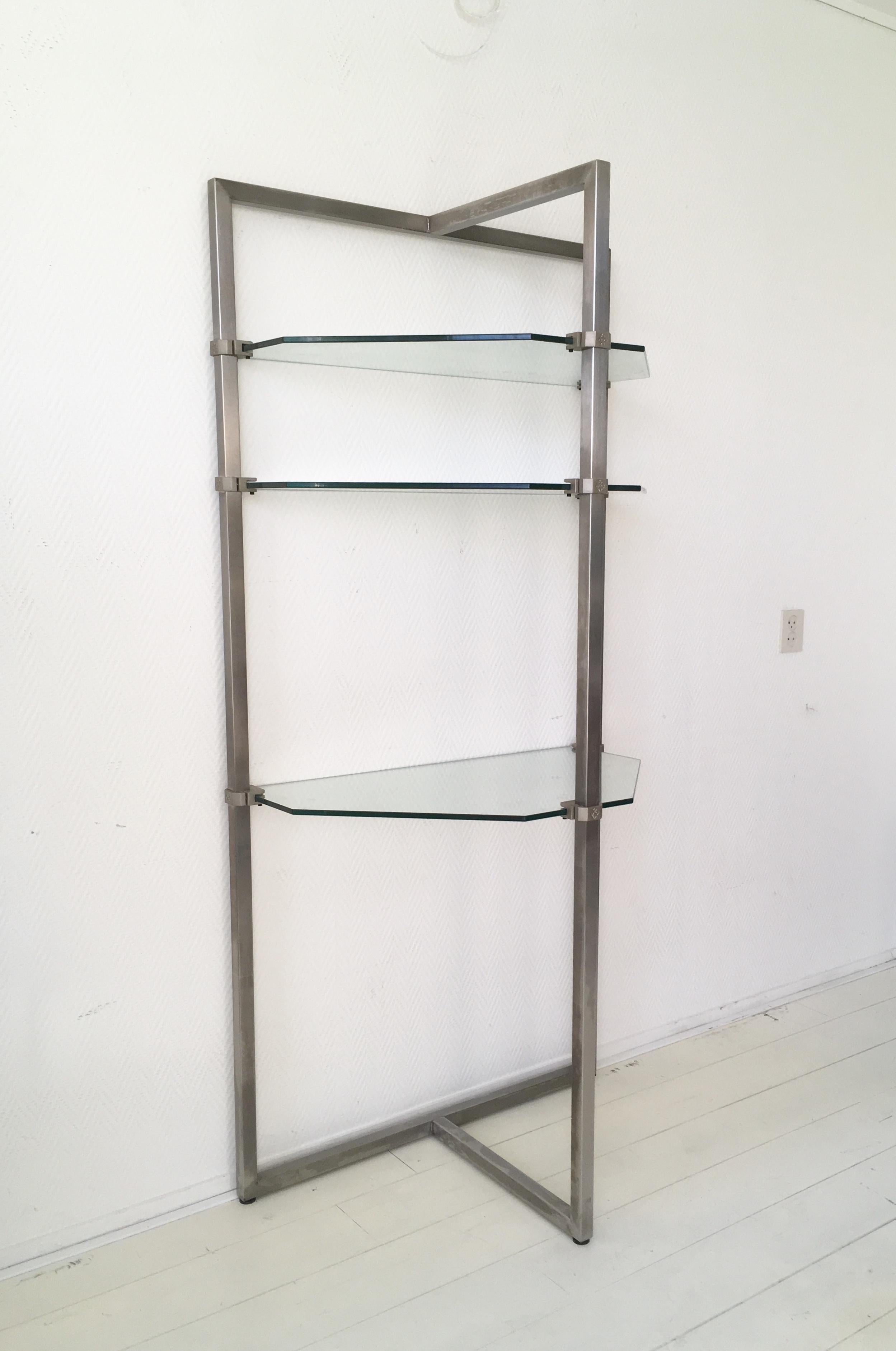 A stainless steel frame constructed of 3 × 3 cm stainless steel tubing holds brackets for glass shelves that may be placed at any height. The brackets were sand cast. The 10 mm glass plates were finished in clear glass. Each glass plate floats