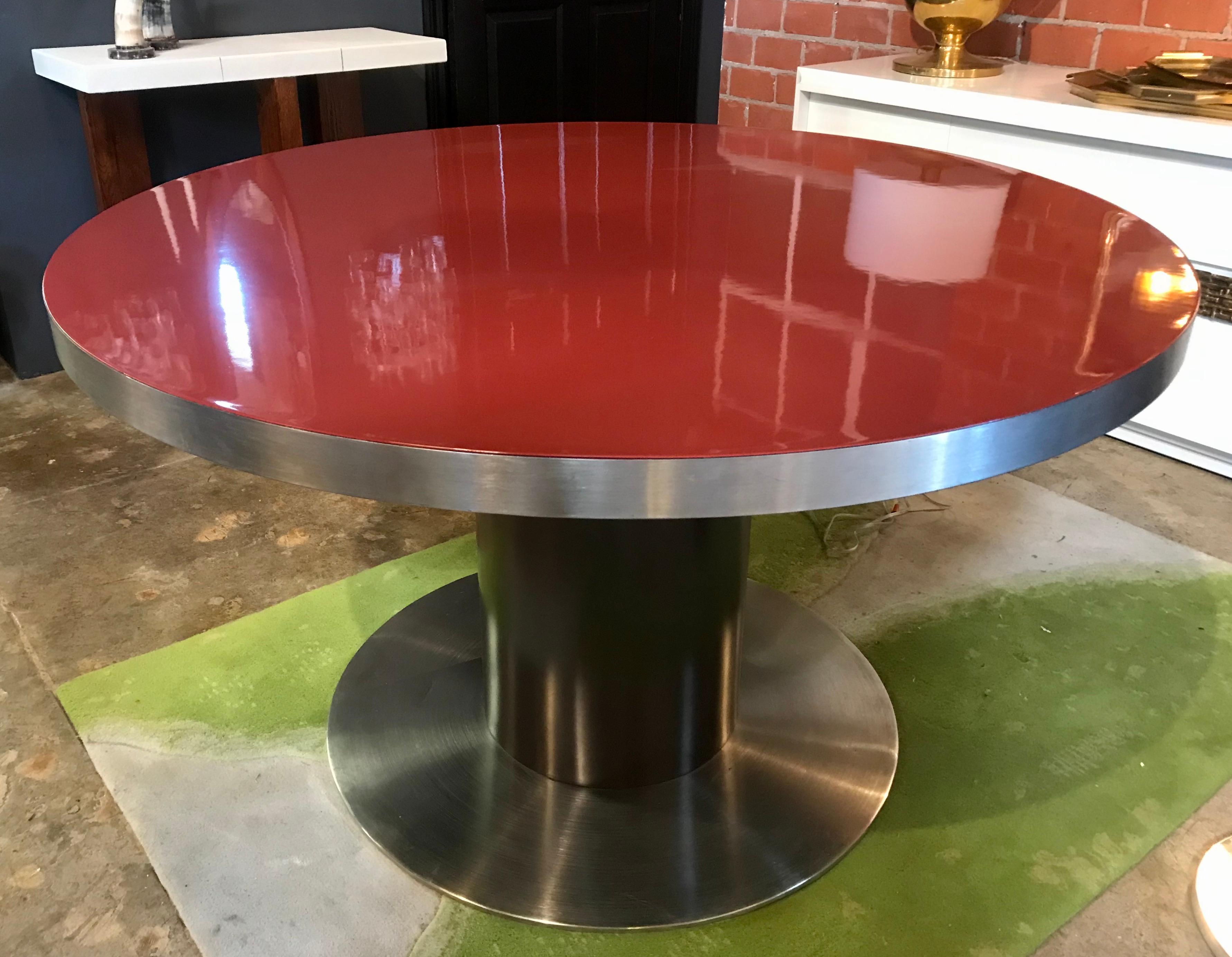 A rare glamorous polished stainless steel and red top dining table designed by Willy Rizzo in the 1970s.
The table (diameter 51 in.) a polished stainless steel disk that secures the top to the polished stainless steel base.
The diameter of the