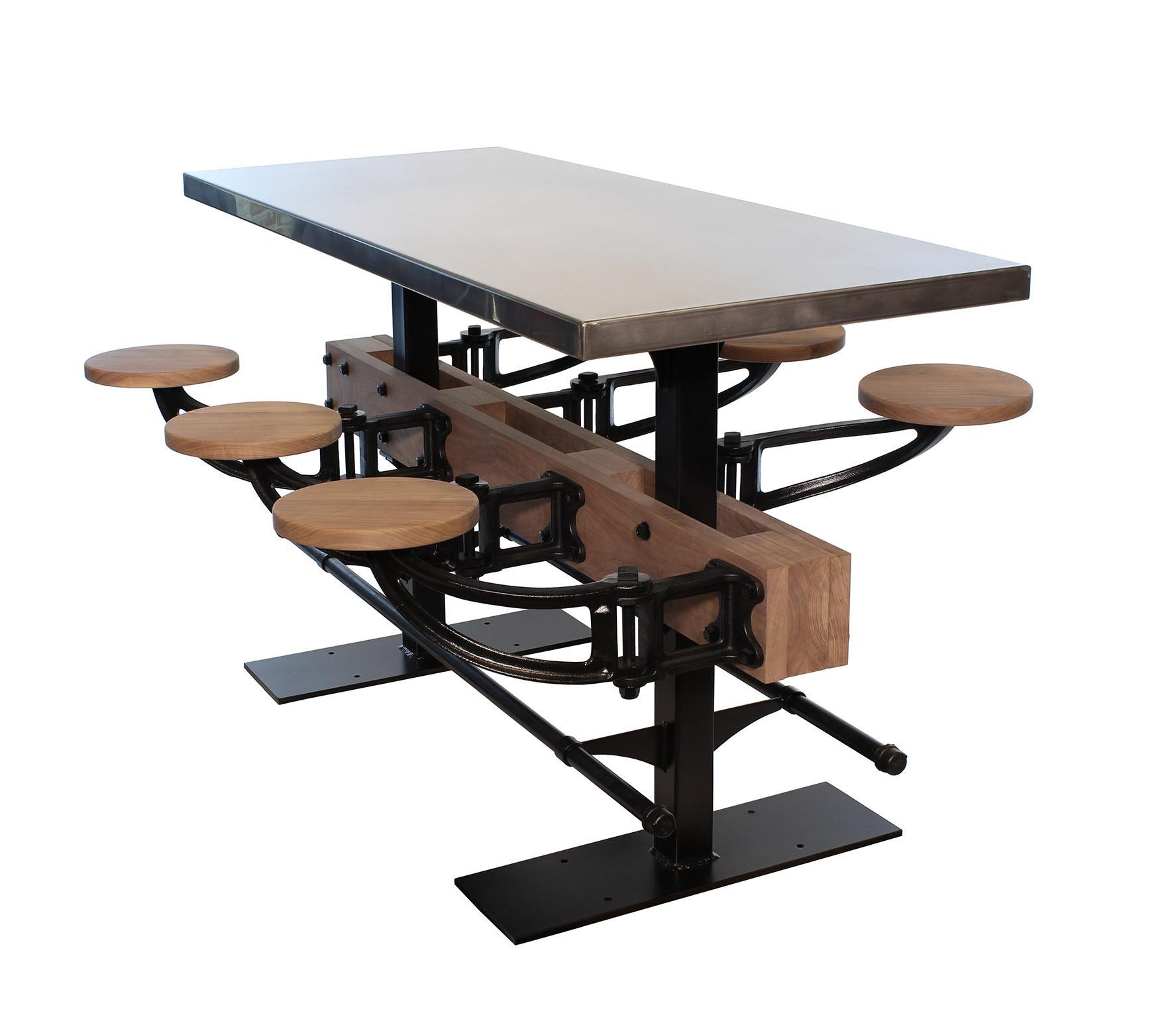 Custom built stainless steel pub height cafe table with cast-iron swing-out seats. Shown in 6-seat model in raw walnut with a foot-rail. Seat arms are cast from ductile iron and are stress tested to over 1000 pounds. Table shown measures 30
