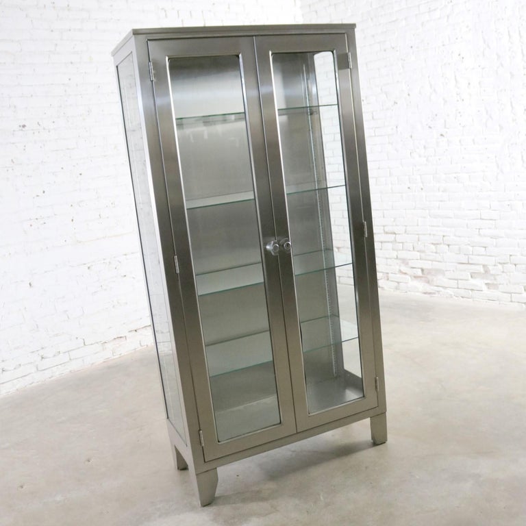 Incredible industrial stainless-steel medical or apothecary cabinet with glass doors, sides, and shelves that allow it to make the best display cabinet ever. It is in exceptional vintage condition. Any imperfections, i.e. scratches and dings, are
