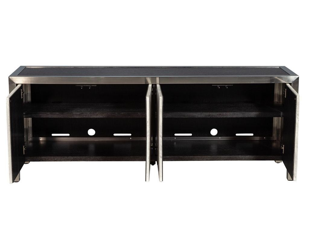 Stainless steel modern console sideboard with stone door fronts. Featuring ebonized oak top and interior with cutout for multimedia devices, perfect for a living room setting.

Price includes complimentary curb side delivery to the continental USA.