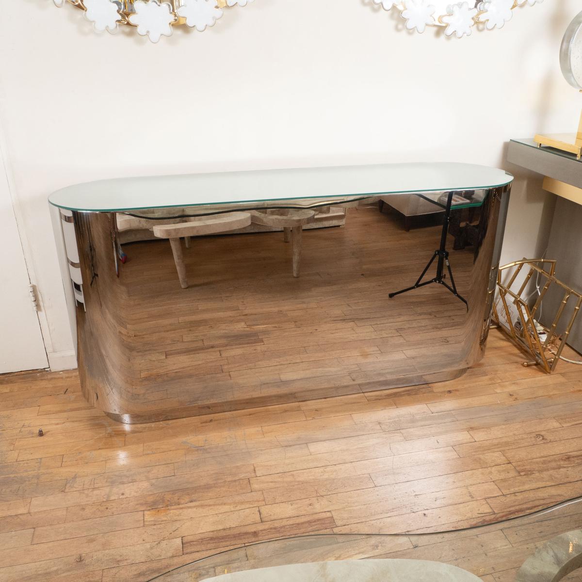 Stainless steel oval console with glass top.