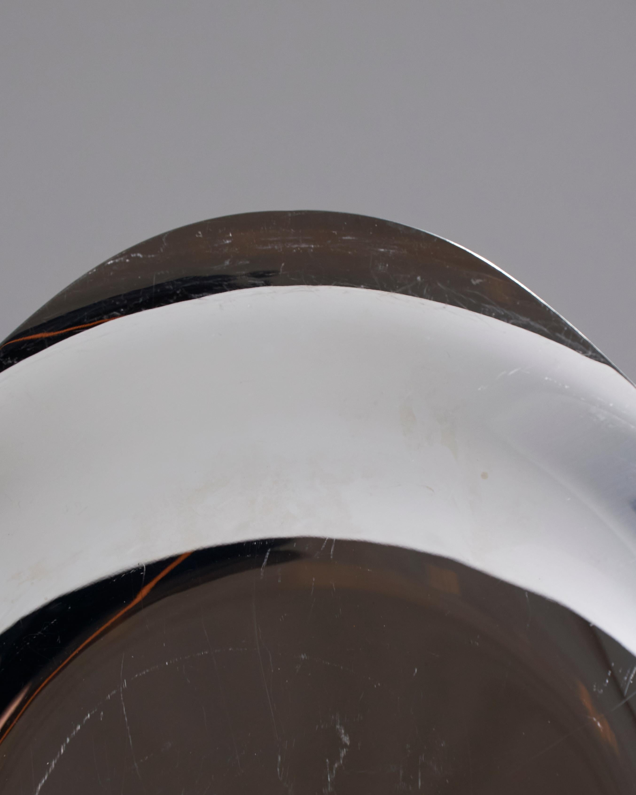 Plateau triangulaire aux angles adoucis en acier inoxydable poli. Cette pièce minimaliste et intemporelle peut servir de fourre-tout, de centre de table ou de plateau de service. Légères traces d'usure dues à l'âge.