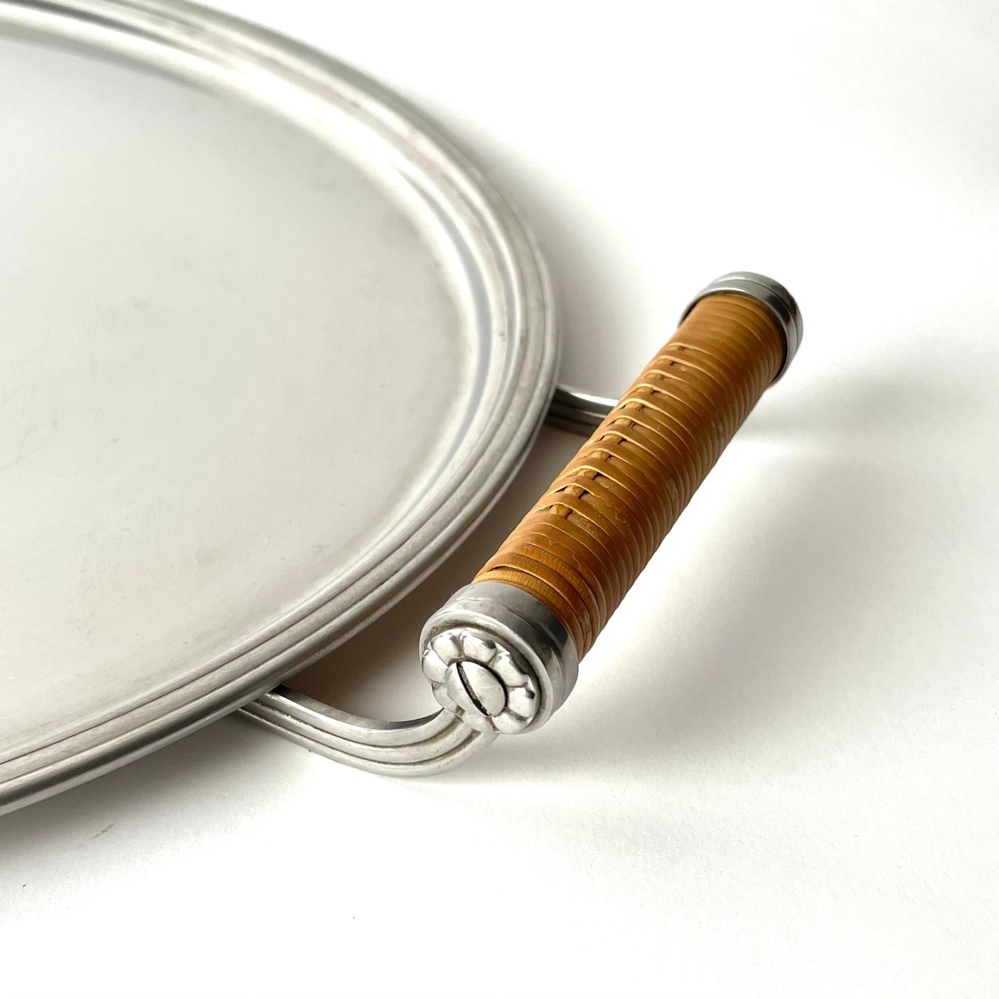 Stainless Steel Serving Tray with Rattan-Wrapped Handles. 
Made in Sweden during the 1930s-1940s. Designed and produced by the famous Swedish company Gense, based in Eskilstuna, Sweden. Gense was one of the leading producer of elegant and