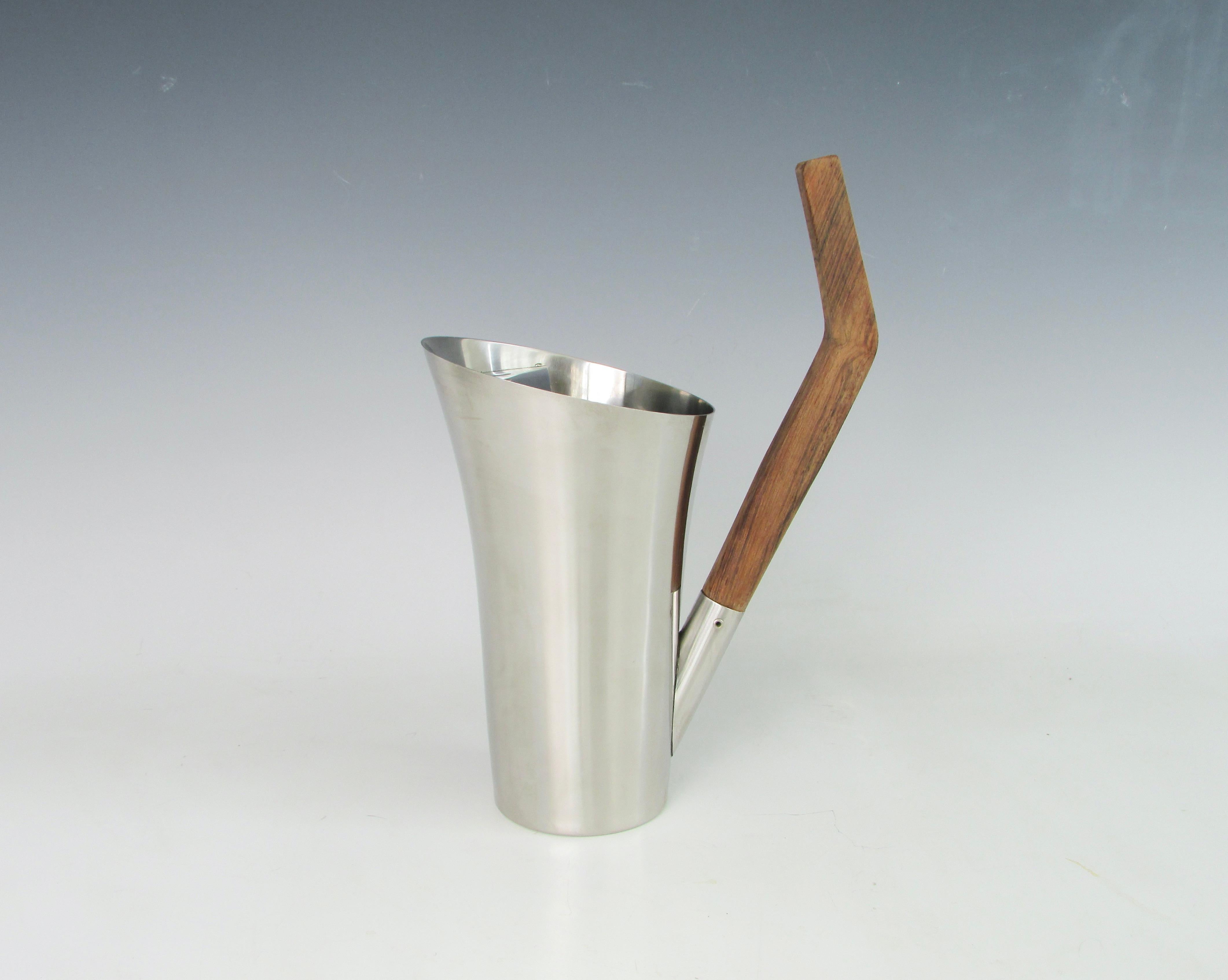 Stylish asymmetrically styled cocktail pitcher. Solid rosewood handle attached to stainless steel body of pitcher. Narrow bottom flairs open at the top to internal Ice strainer. Measures ten inches to top of handle pitcher itself is 7