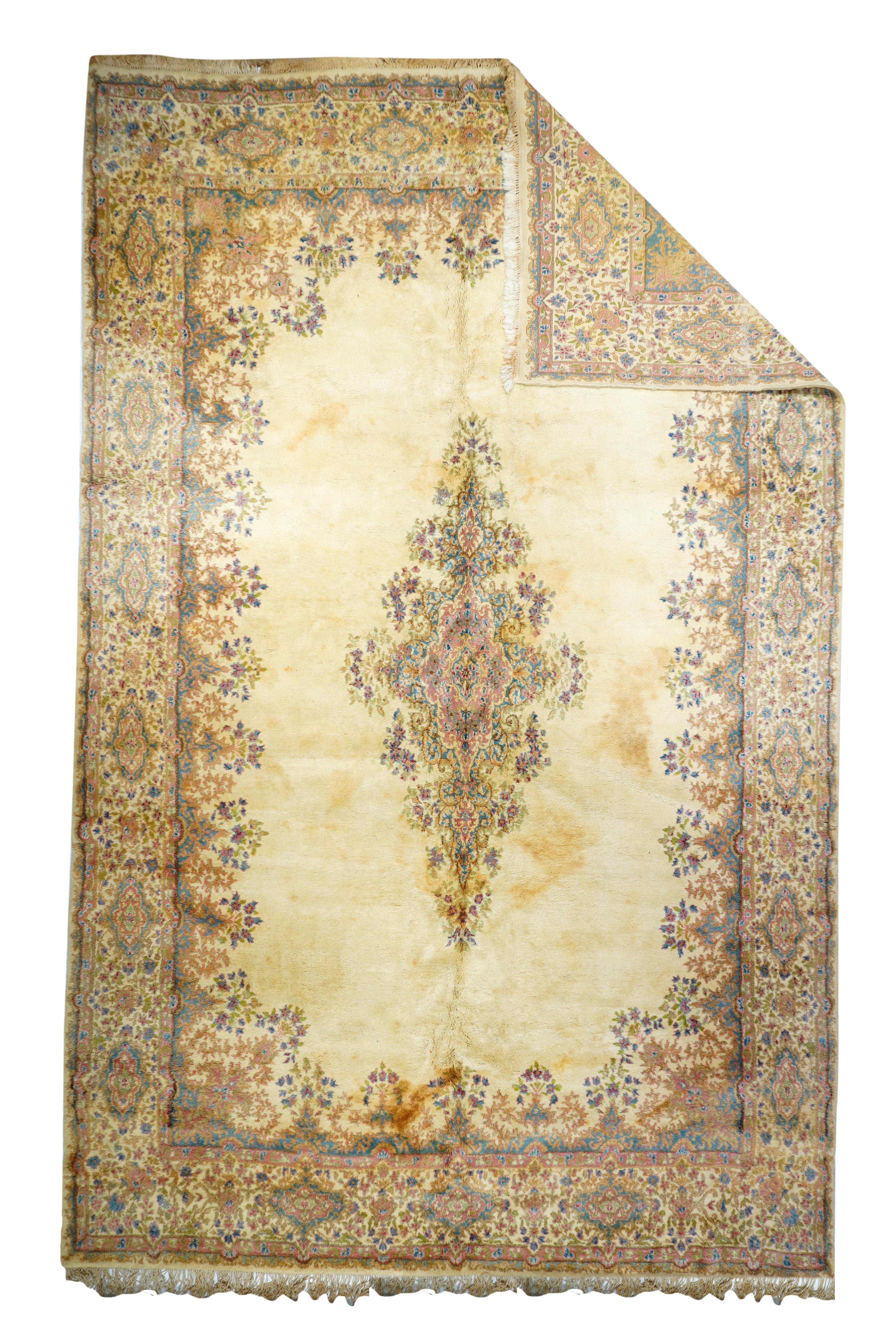Now compromised by staining, this vintage SE Persian city weaving shows an open sandy-ecru field edged with filigree floral elements, and hosting a filigree floral medallion. Sandy-ecru border with cartouches. Lush pile, medium weave. Fairly good