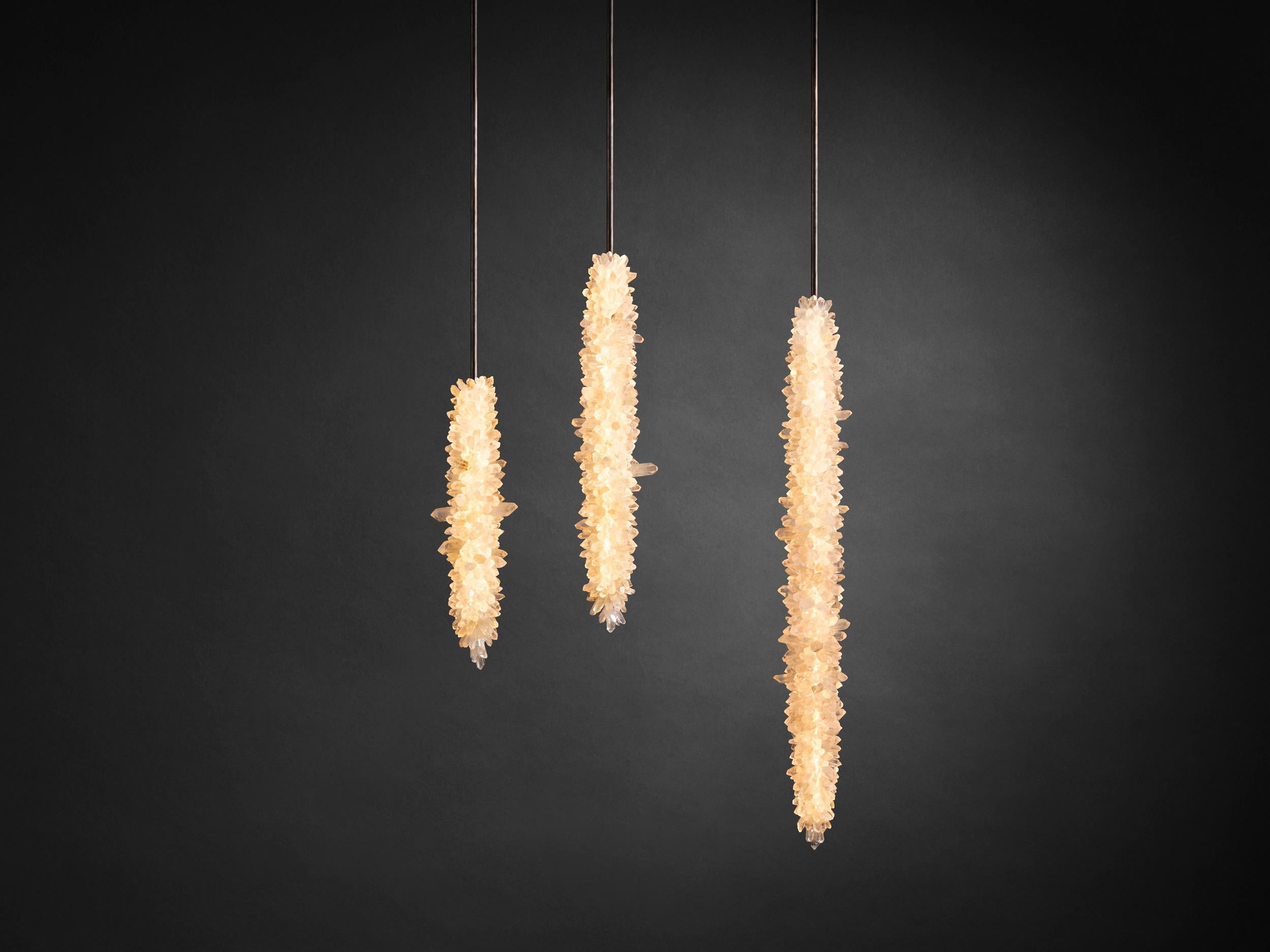Lampada a sospensione Stalactite 60 di Christopher Boots
Dimensioni: D 13,5 x H 60 cm.
Materiali: Cristalli di quarzo naturali non tagliati, ottone.

Disponibile in quarzo chiaro, fumé o sfumato.
Disponibile con altezza di 45 cm, 60 cm o 90