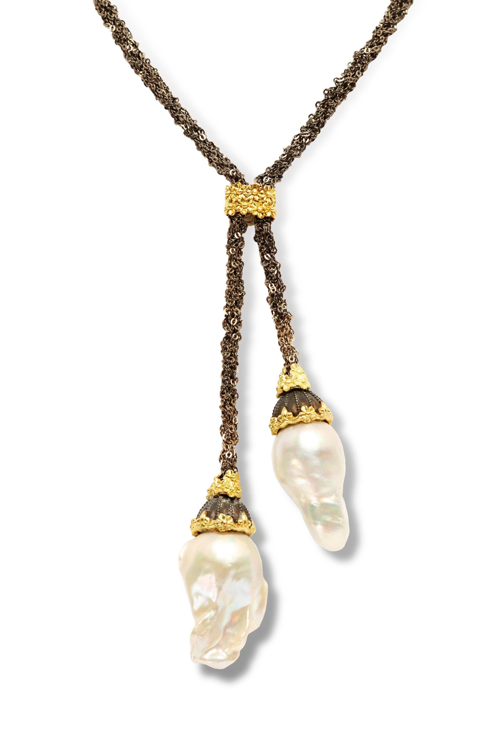 Chaîne en argent vieilli Stambolian Mesh  Collier Lariat en or 18K et perles baroques 

Ce collier unique est composé d'une magnifique chaîne en maille reliée au centre par un motif floral en or.

Le design mène à deux gouttes avec des perles